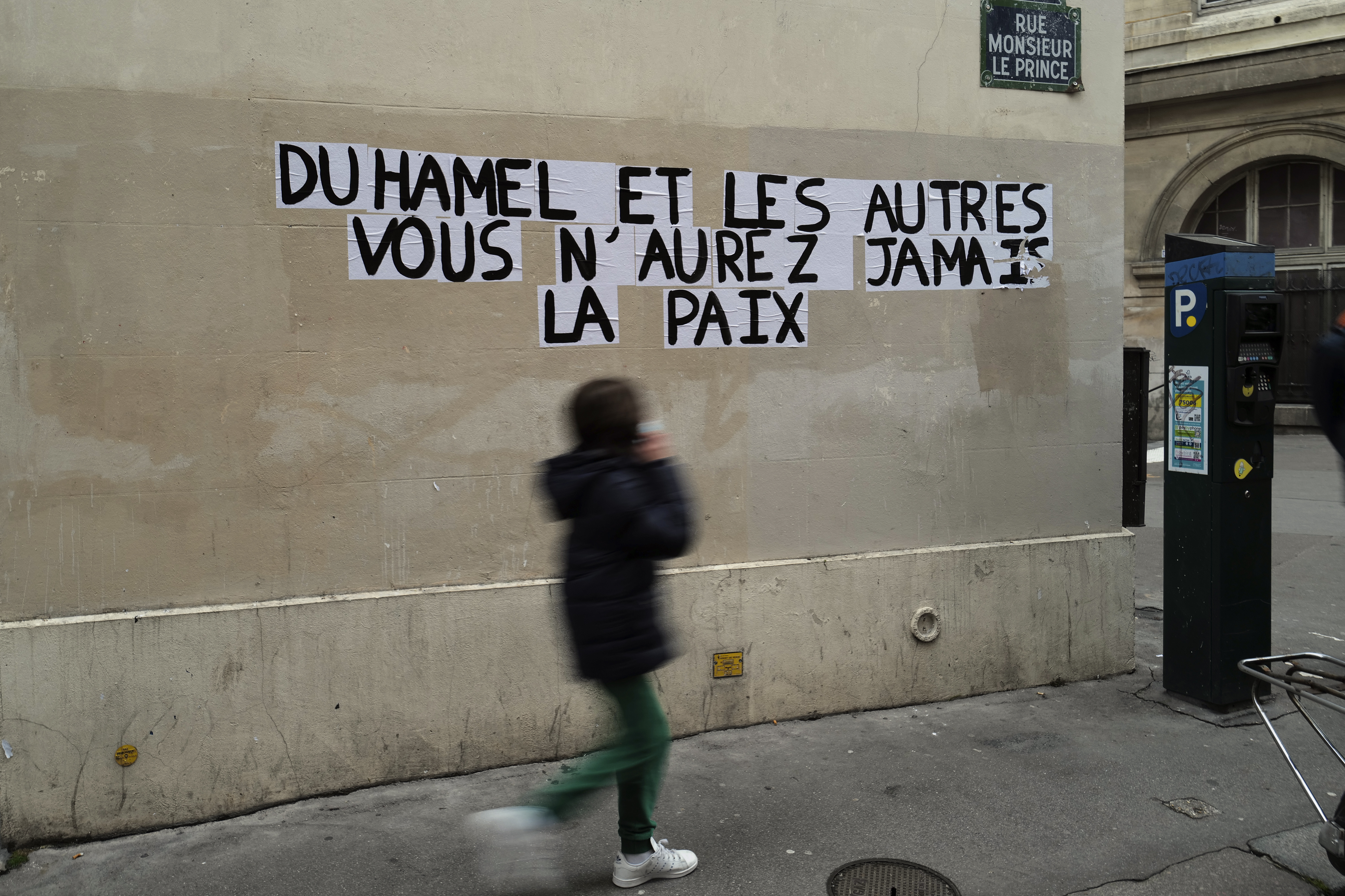 A sign on a Parisian wall reads 'Duhamel, and the others, you will never be in peace', referring to the prominent French political expert Olivier Duhamel, who is accused of raping his stepson [Francois Mori/AP]