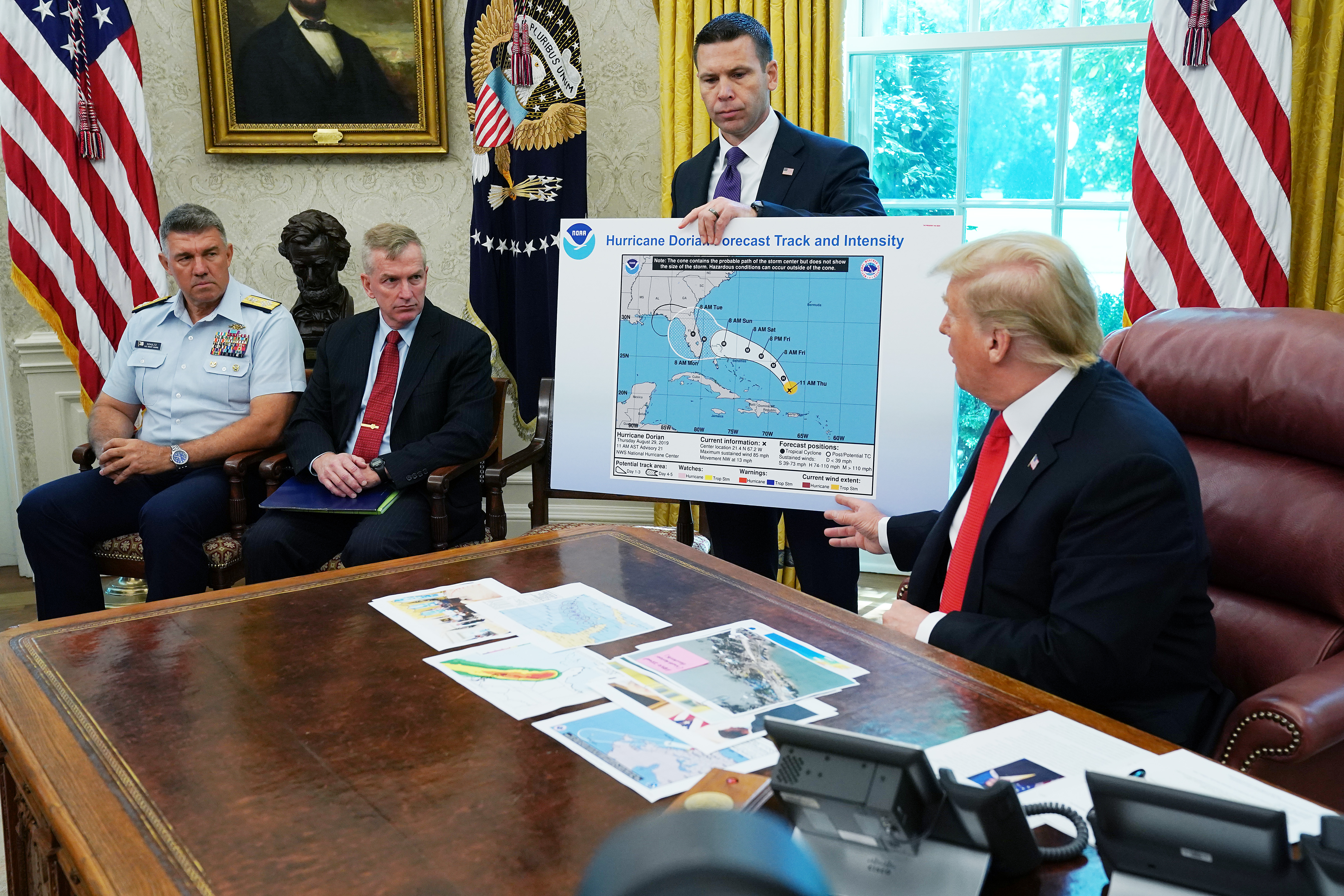 President Donald Trump references a map held by acting Homeland Security Secretary Kevin McAleenan while talking to reporters about Hurricane Dorian in the Oval Office at the White House, September 4, 2019