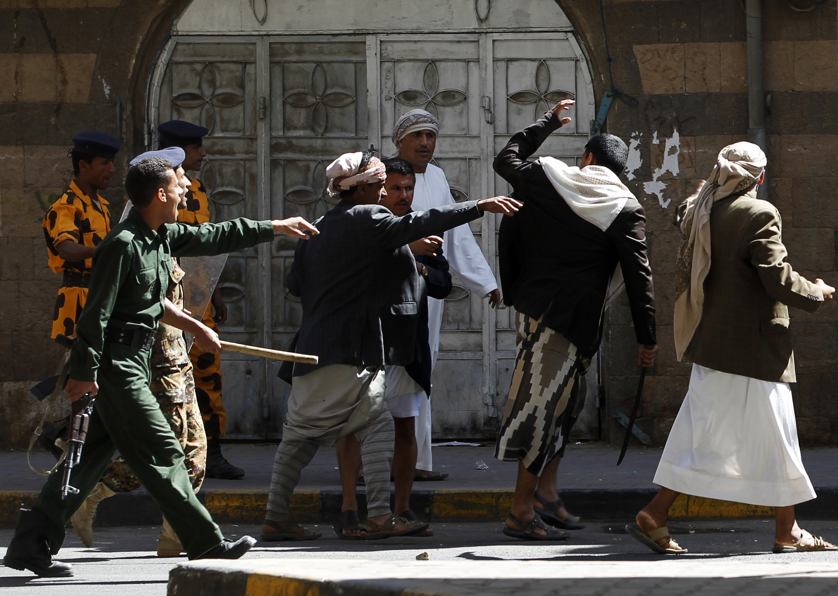 Police try to block government backers as they chase anti-government protesters in Sanaa, Yemen in February 2011