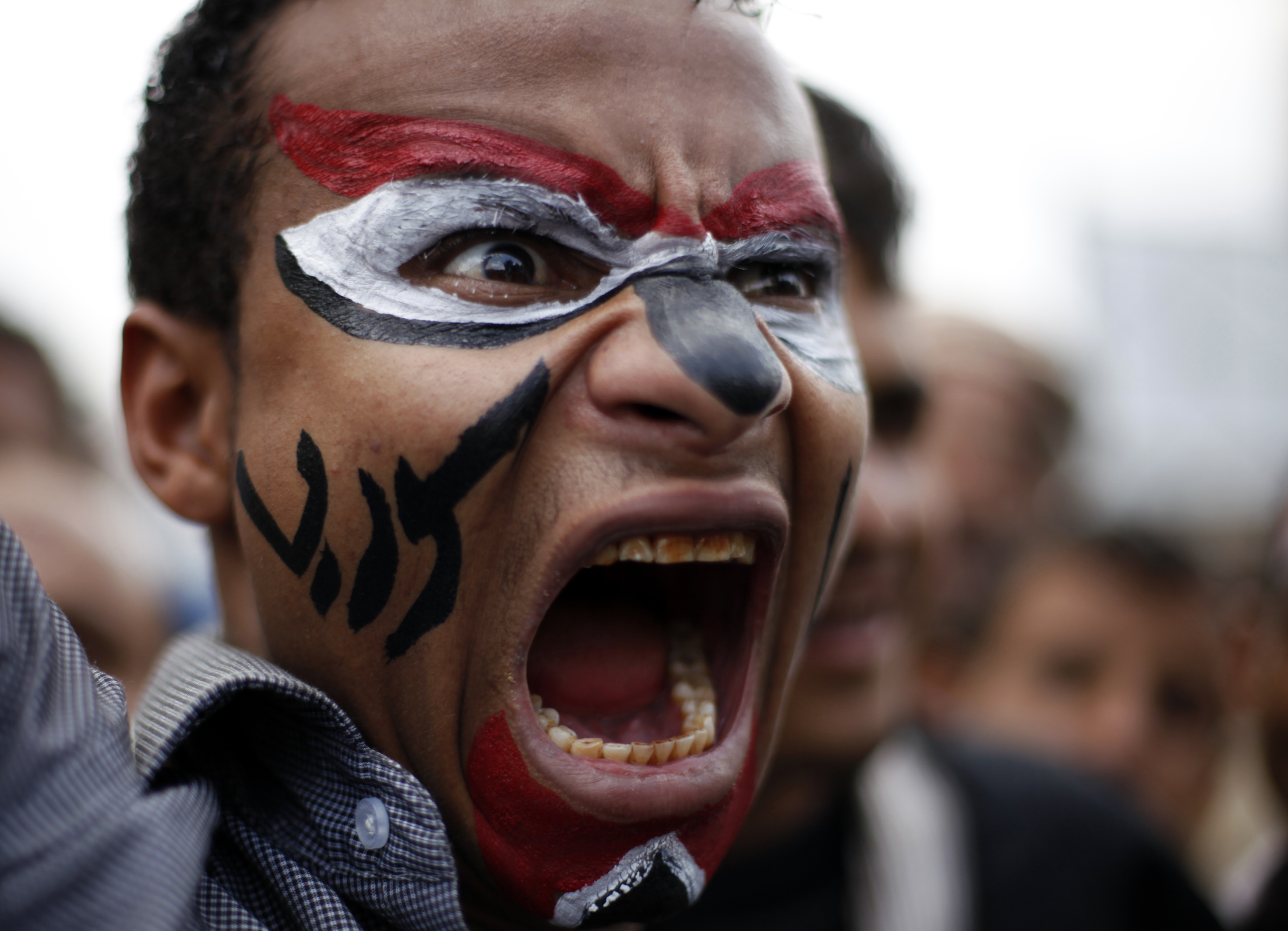 An anti-government protester shouts slogans during a rally to demand the ouster of Yemen’s President Ali Abdullah Saleh in Sanaa on September 15, 2011. The writing on the face writing reads: ‘Syria’