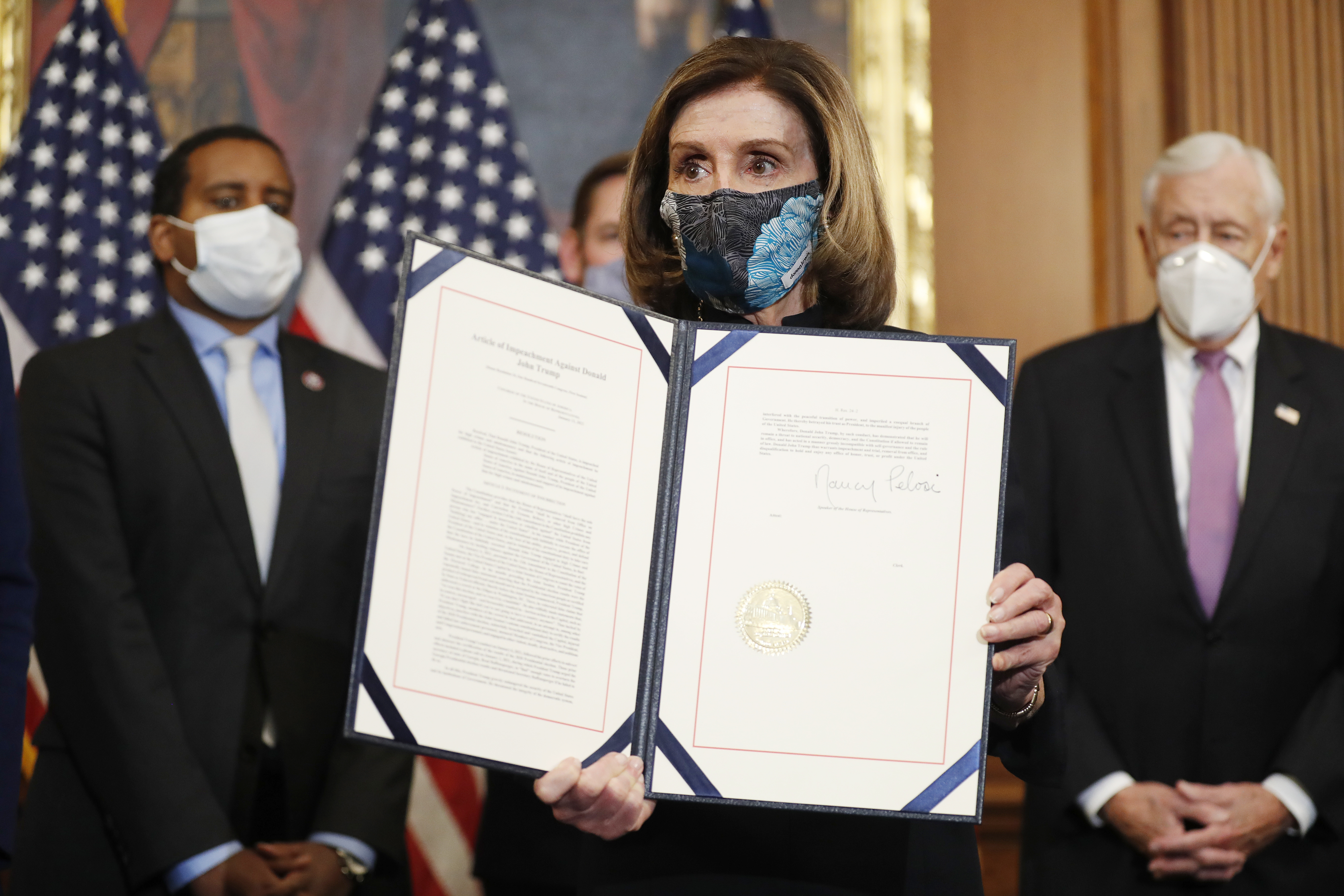 Speaker of the House Nancy Pelosi holds the signed article of impeachment against US President Donald J Trump