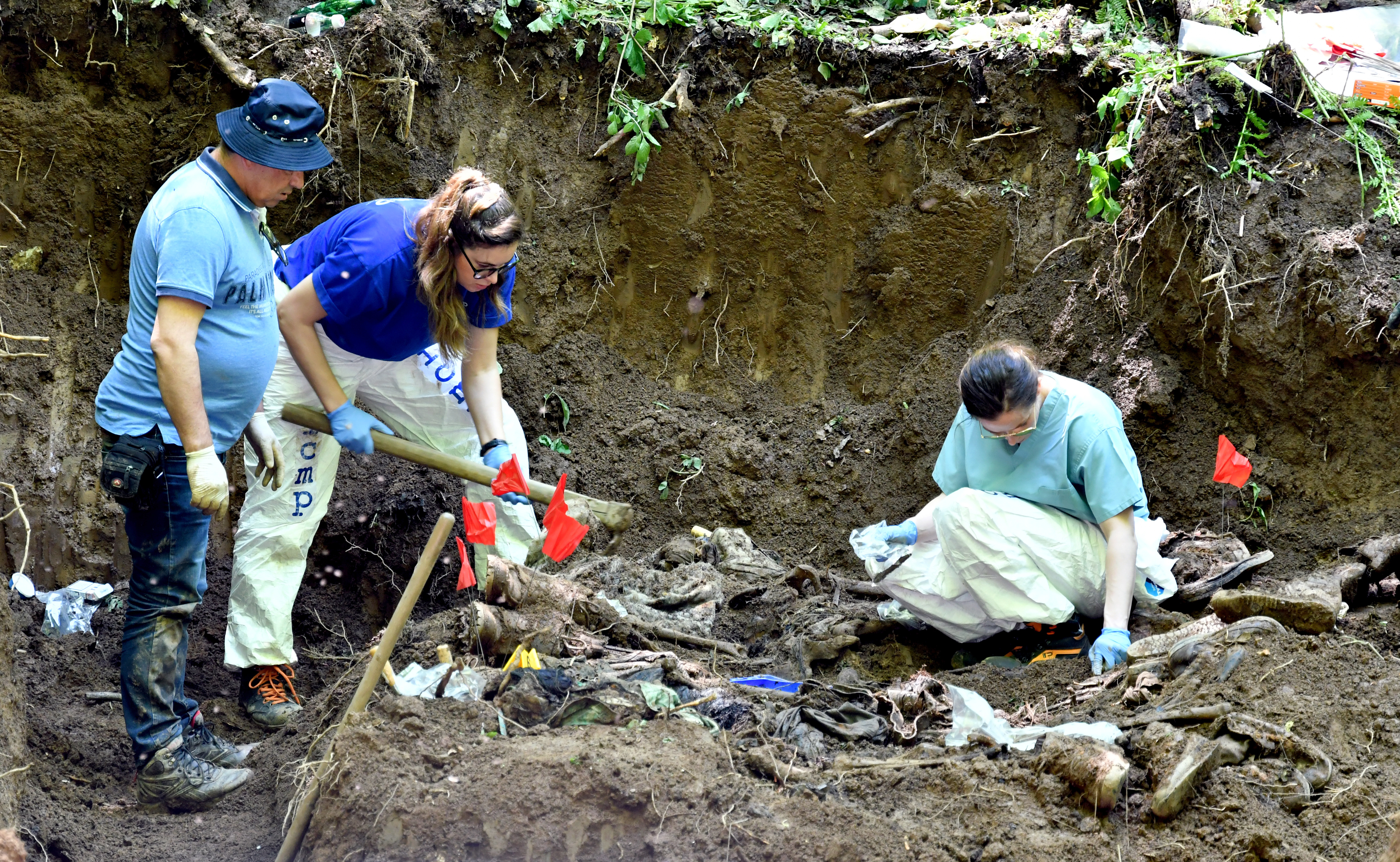 Bosnian workers and ICMP members work on a mass grave on Mt Igman, near Sarajevo, in June 2019. The work is difficult due to mountainous terrain, thick forest and the fact that the area is still littered with landmines