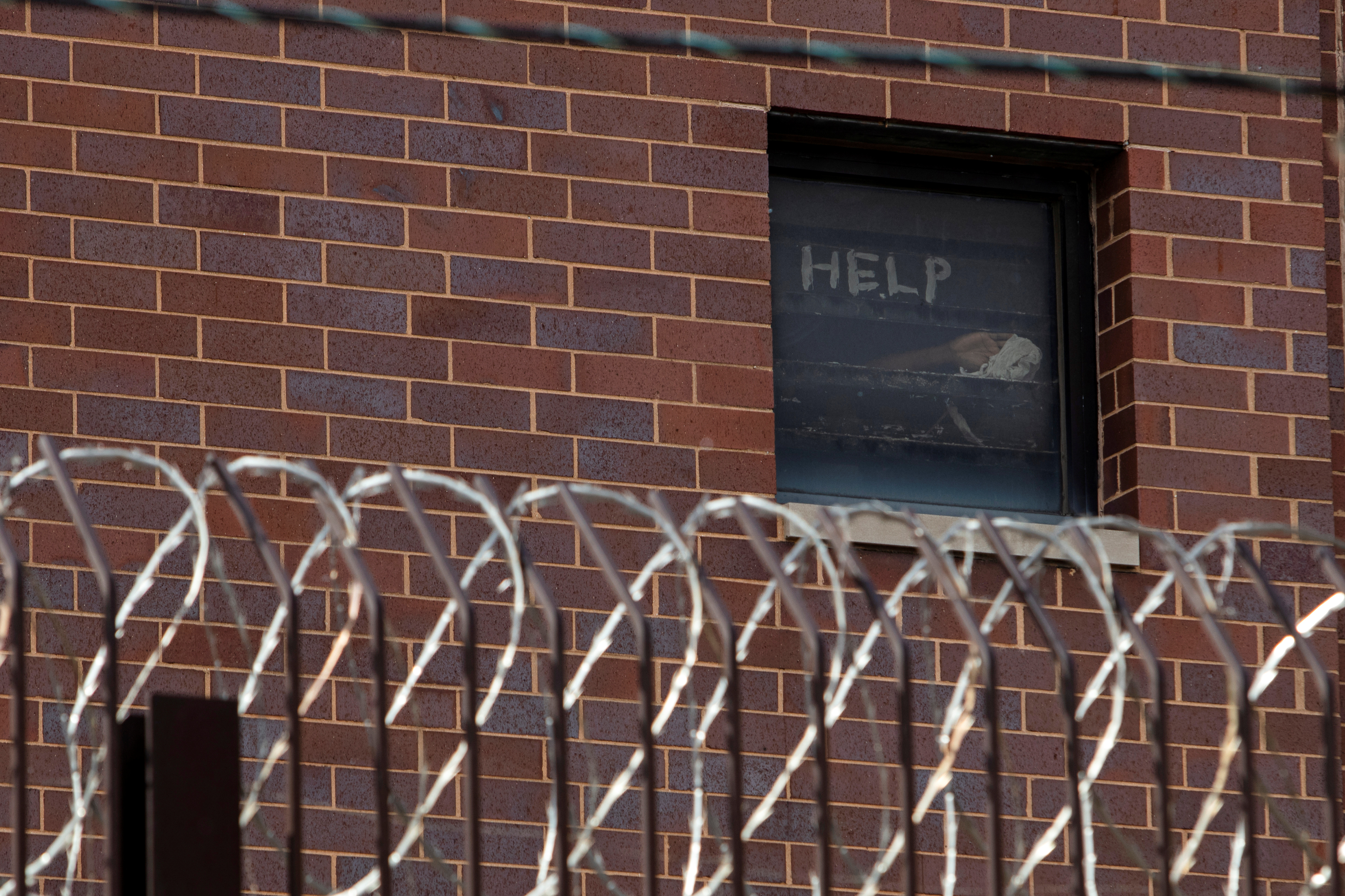 Signs made by jailed people calling for help are seen in a window of Cook County Jail in Chicago, Illinois, in April 2020 amid the coronavirus pandemic