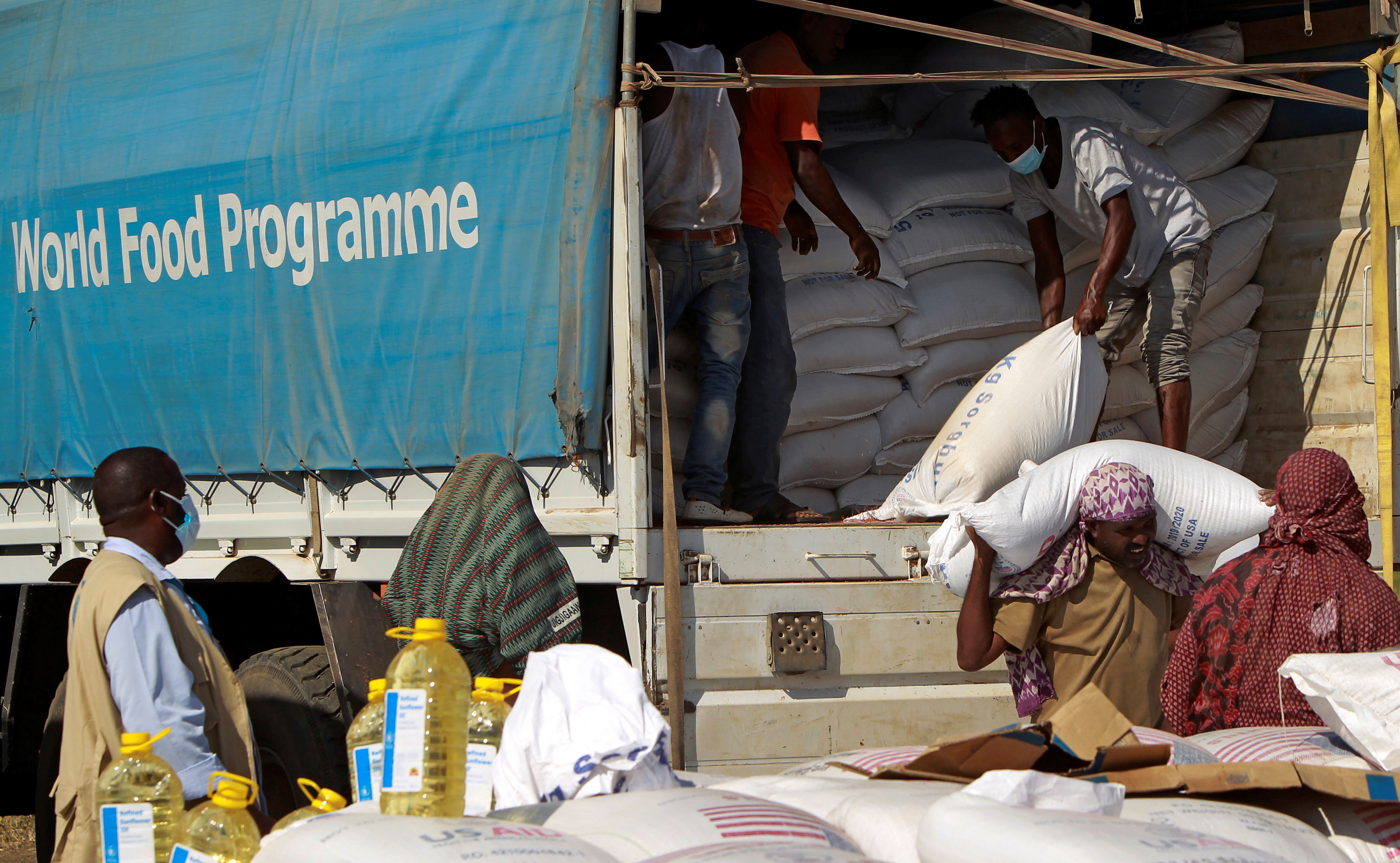 Volunteers and workers from the World Food Programme prepare to distribute relief supplies to Ethiopians who fled war in Tigray region, at the Fashaga camp on the Sudan-Ethiopia border in Al-Qadarif state, Sudan November 20, 2020. REUTERS/Mohamed Nureldin Abdallah