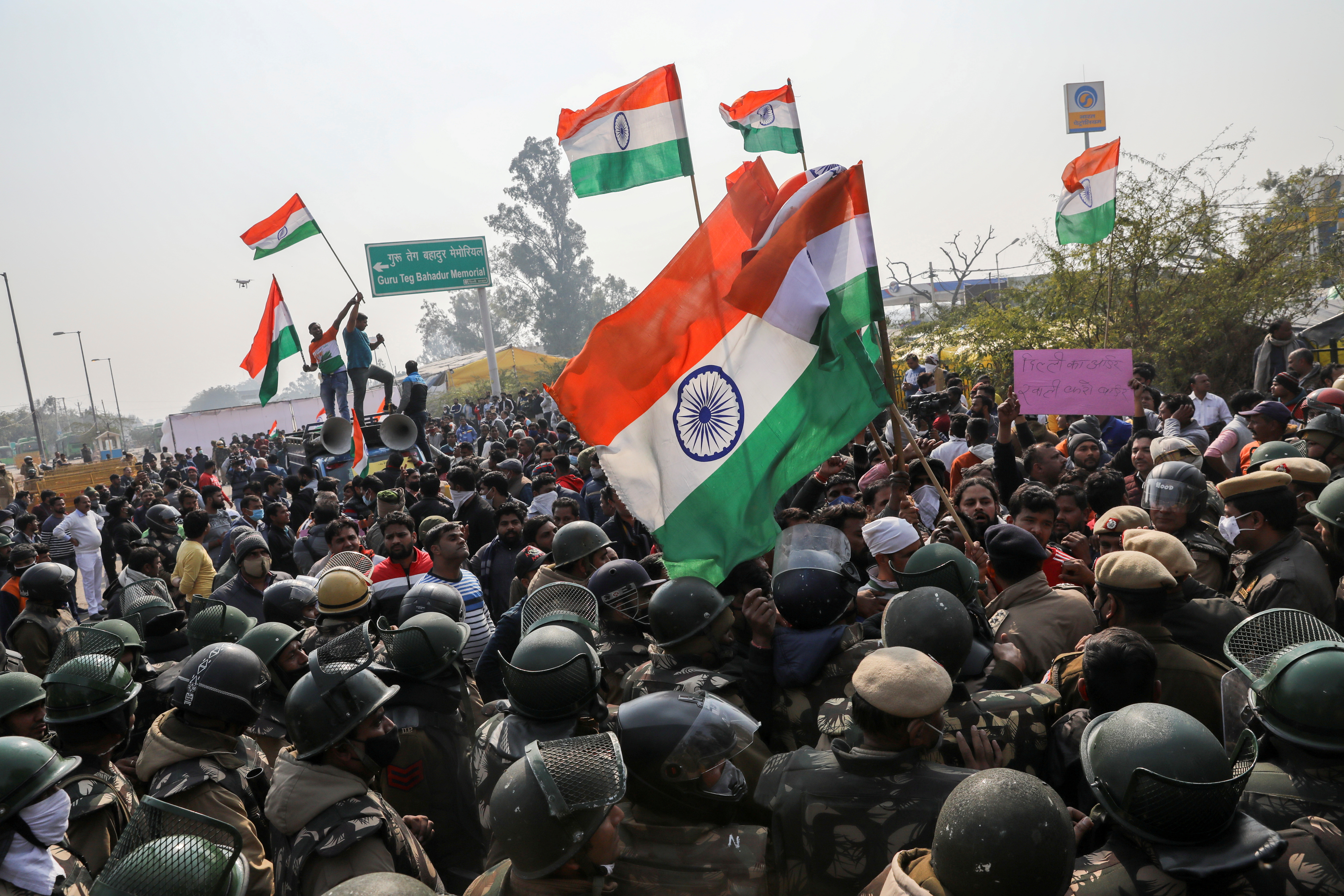 Government supporters raise anti-farmer slogans and wave Indian flags near New Delhi