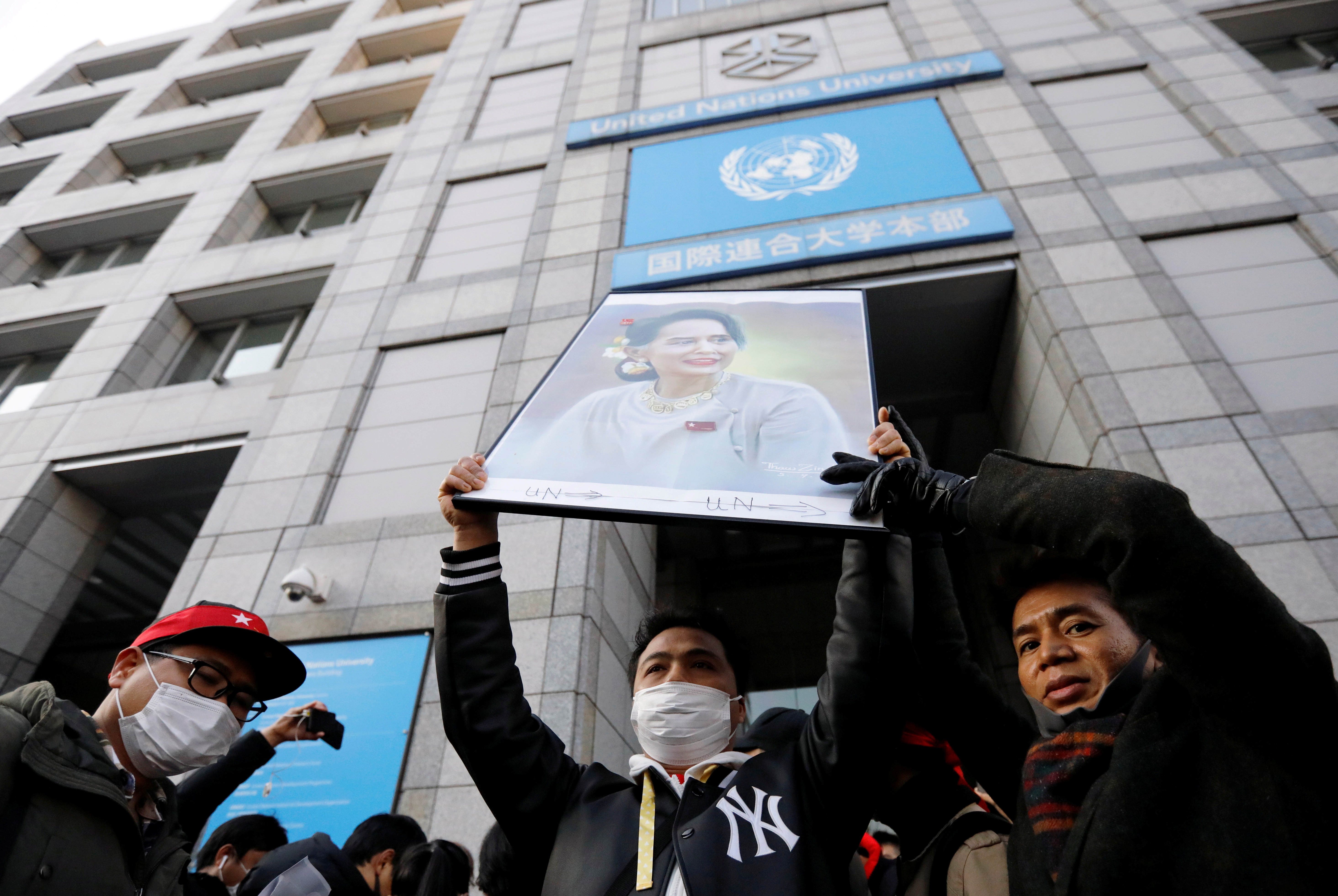 Protesters from Myanmar living in Japan hold a portrait of leader Aung San Suu Kyi at a rally against the military coup outside the United Nations University in Tokyo
