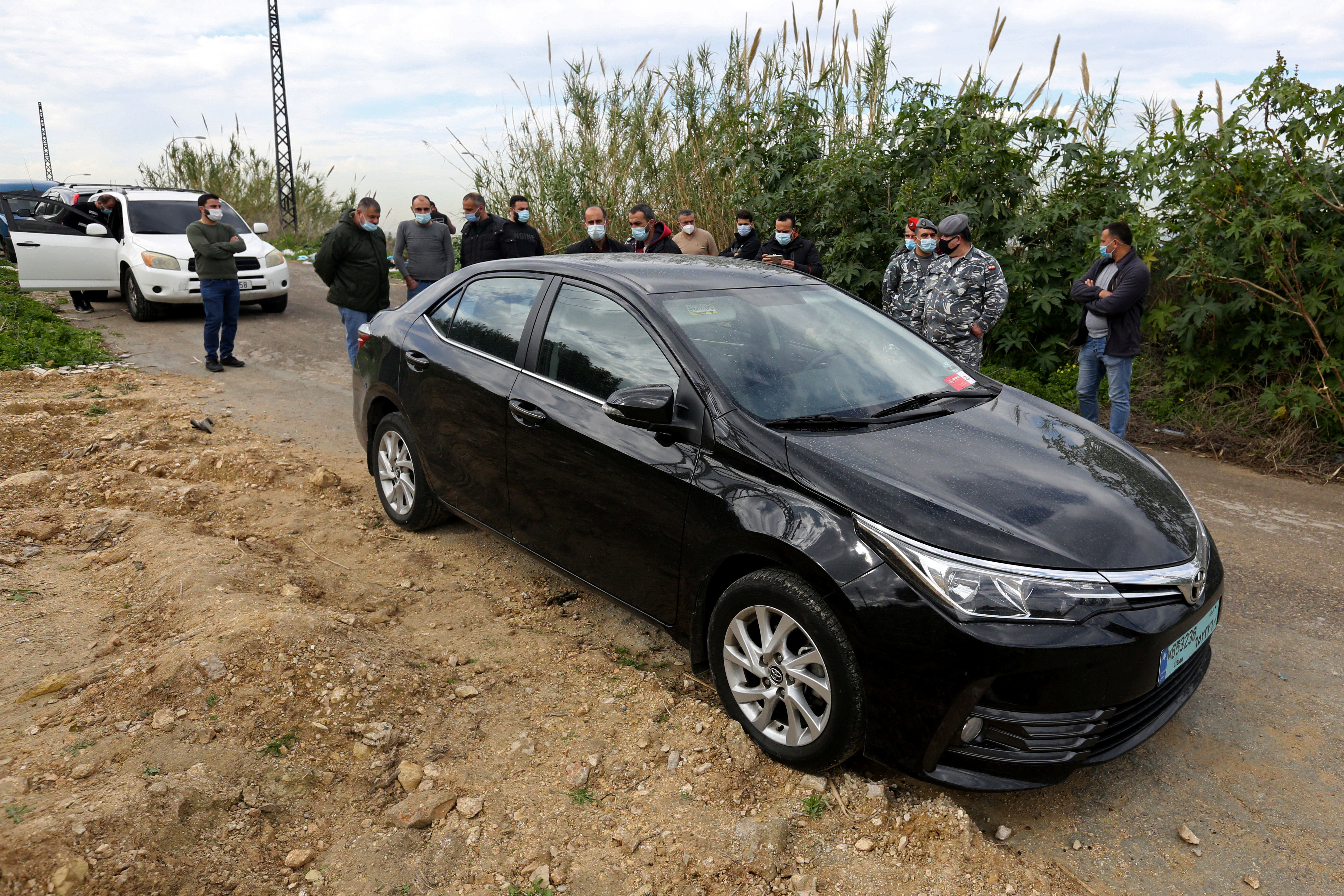 People gather near the car in which Lokman Slim was found dead