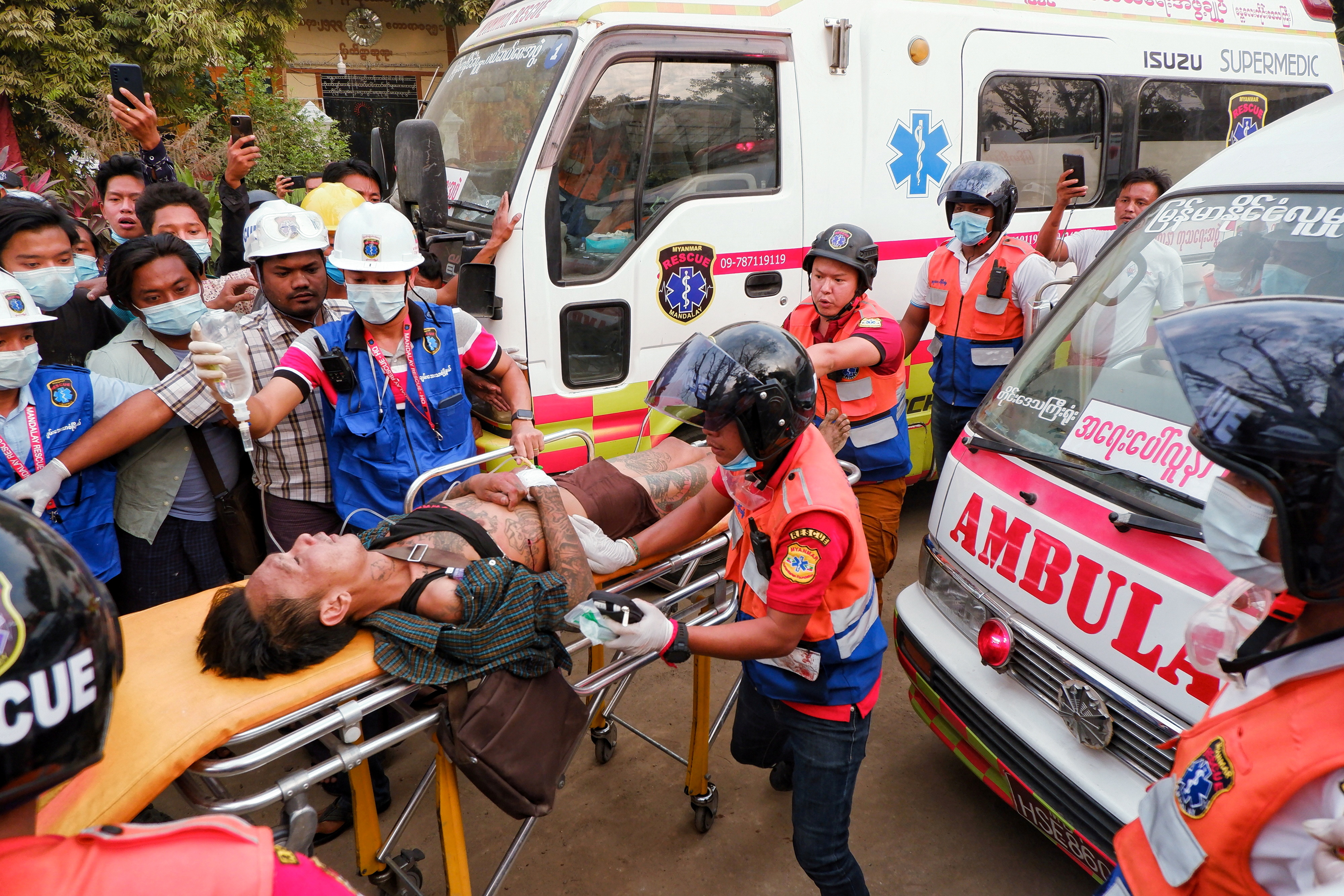 An injured man is carried by rescue workers after protests against the military coup, in Mandalay, Myanmar, February 20, 2021