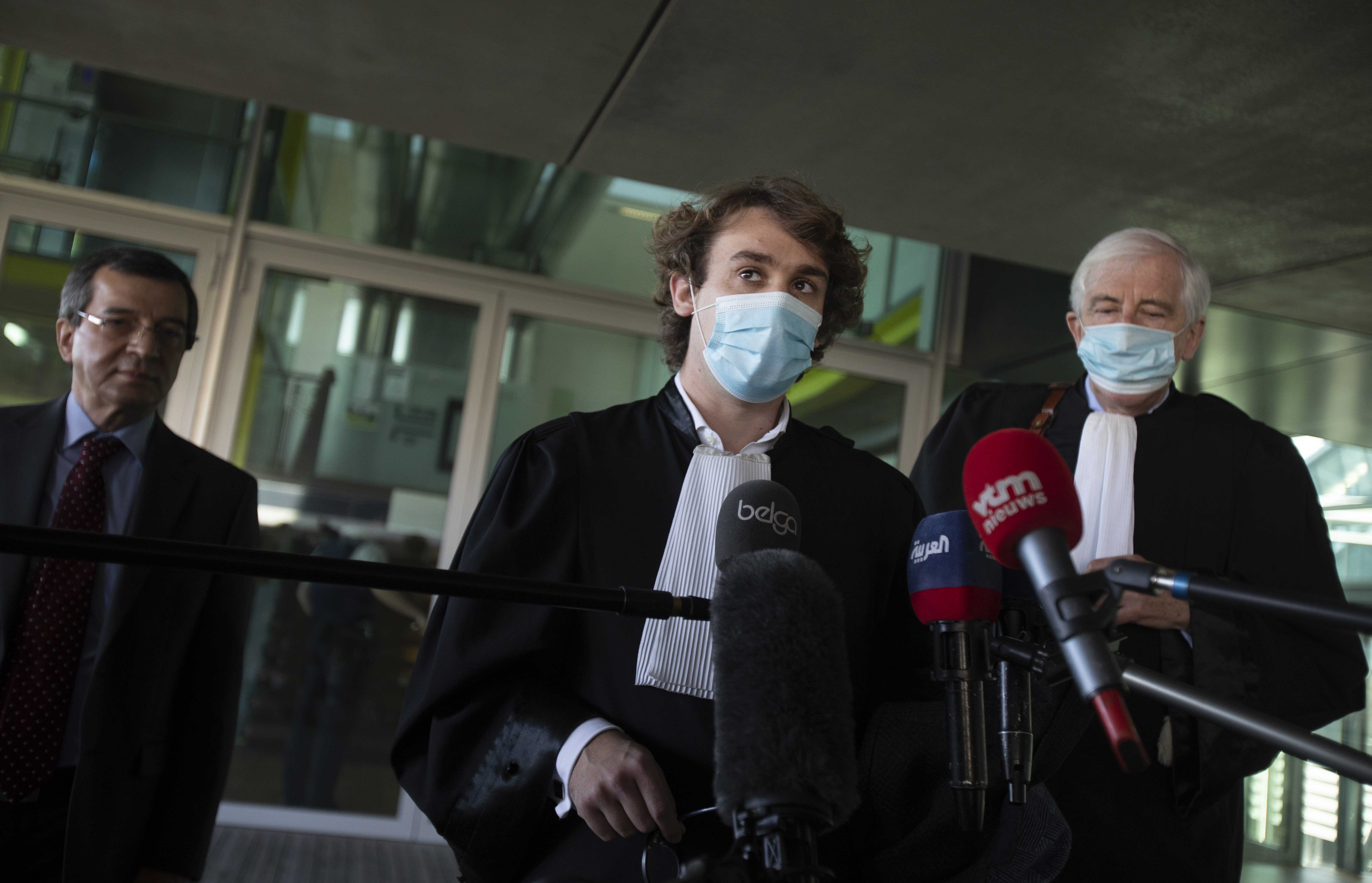 Lawyers George Henri Beauthier, right, and Rik Vanreusel, centre, representing the National Council of Resistance of Iran, speak to the media at the court in Antwerp