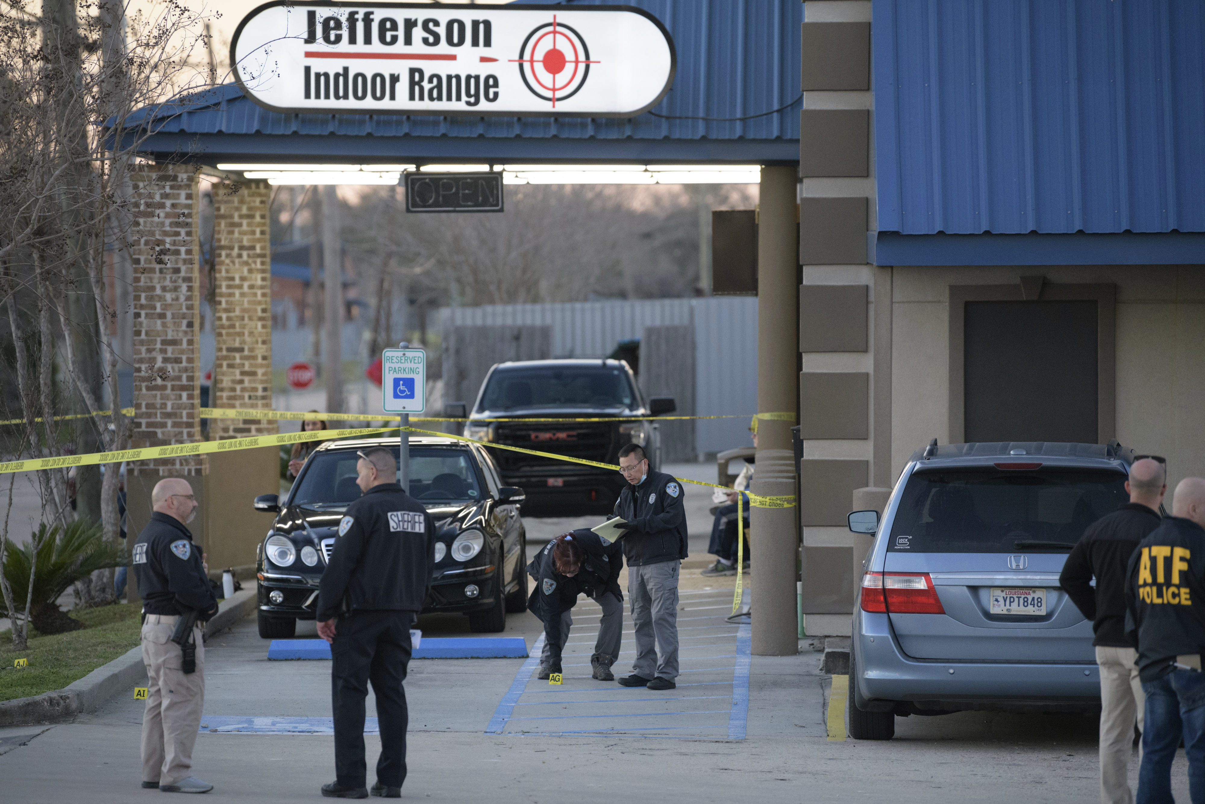 Investigators look for evidence at the scene of a shooting at the Jefferson Gun Outlet in Metairie