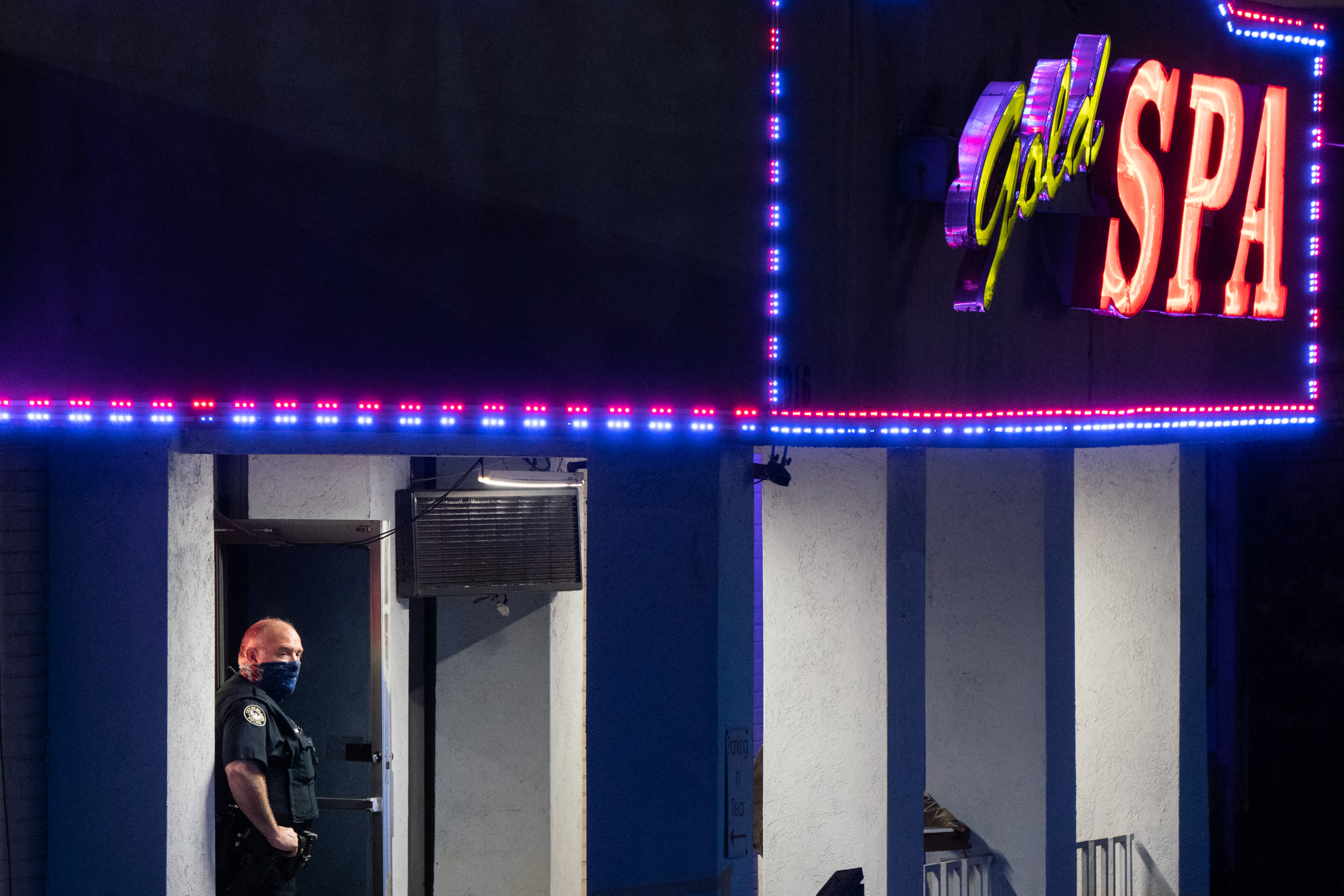 A police officer stands outside a massage parlour where three people were shot and killed on March 16, 2021, in Atlanta, Georgia