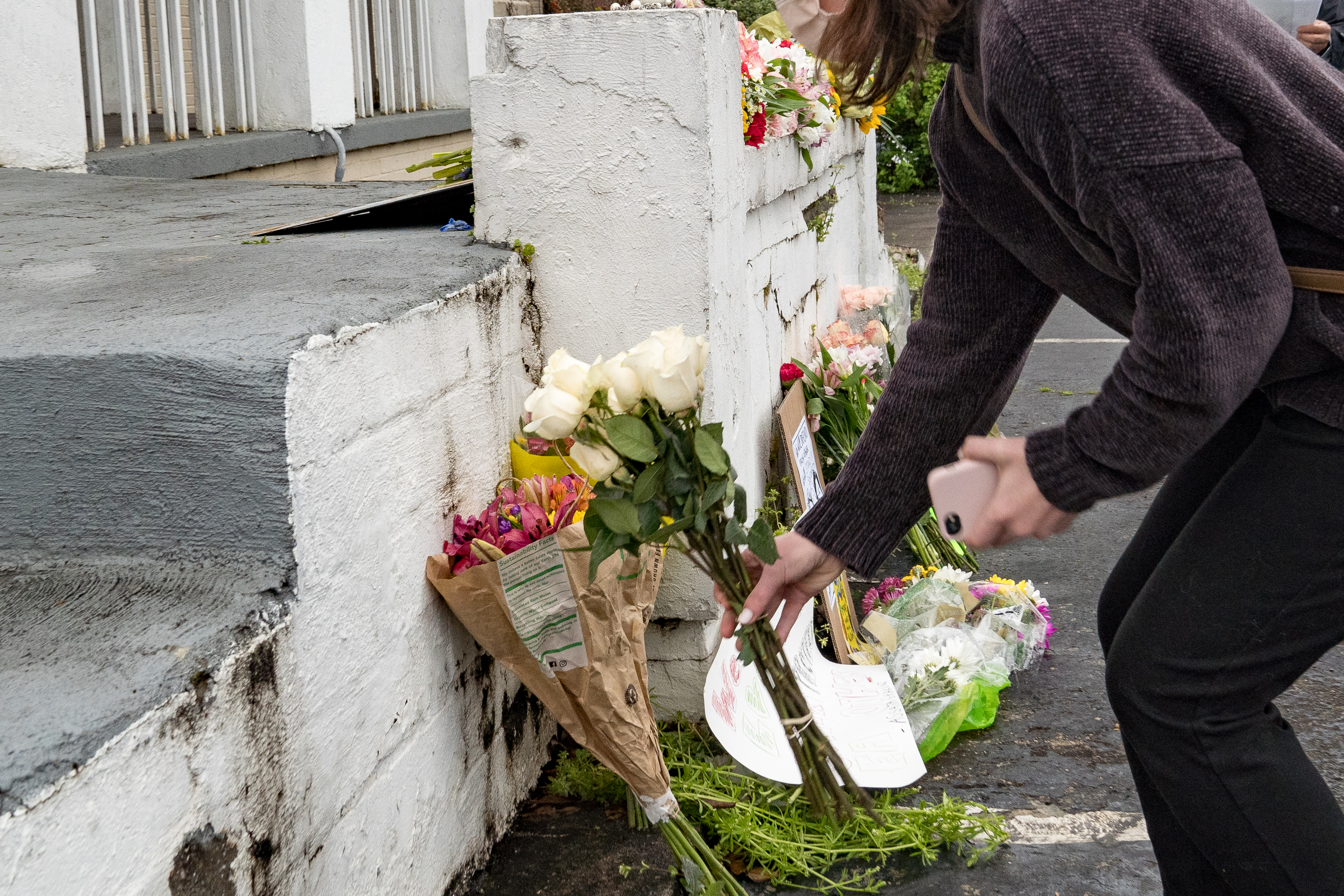 Mourners visit and leave flowers at the site of two of the shootings that occurred on March 16 at spas in Atlanta