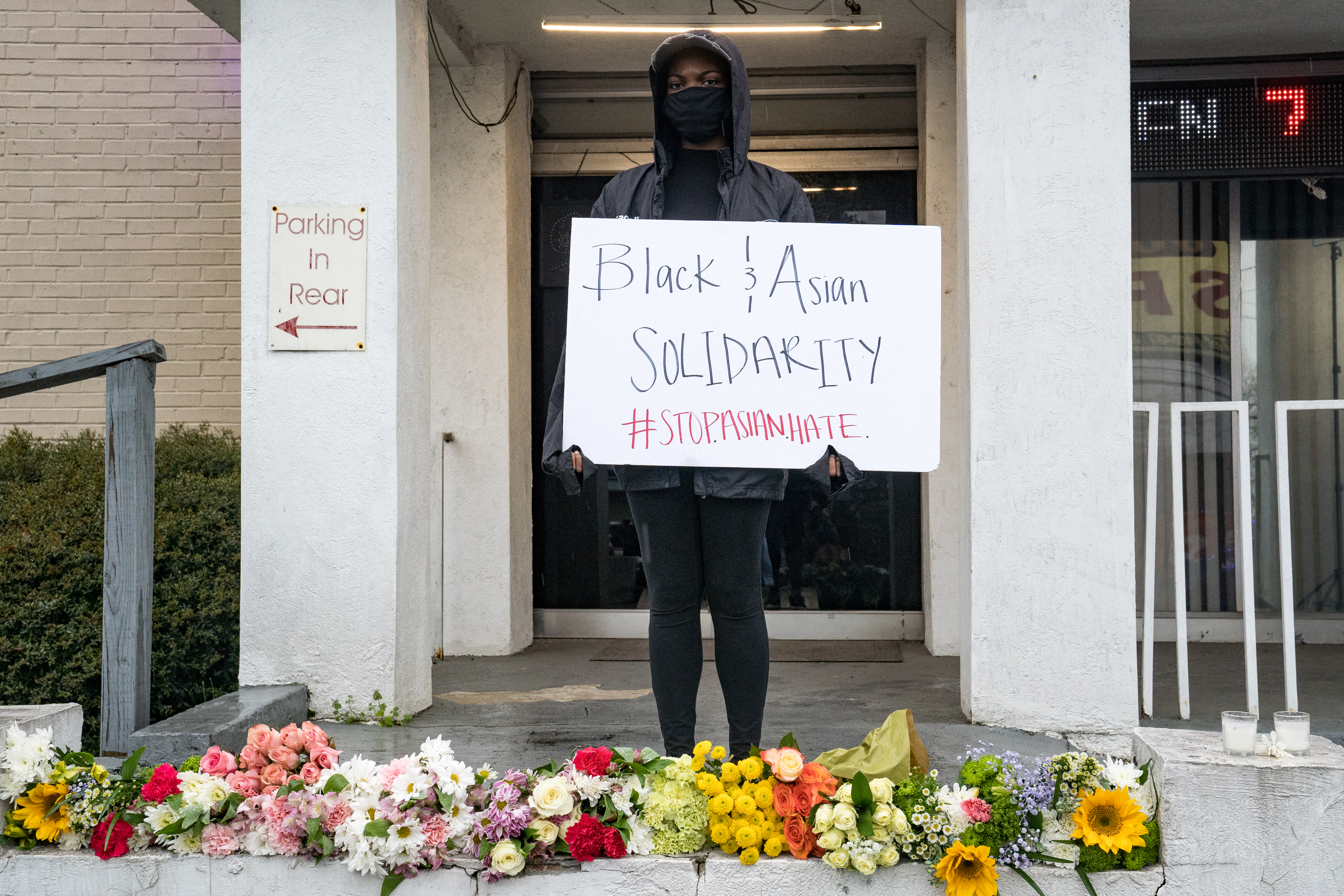 A mourner with a sign reading ‘Black and Asian Solidarity #StopAsianHate’
