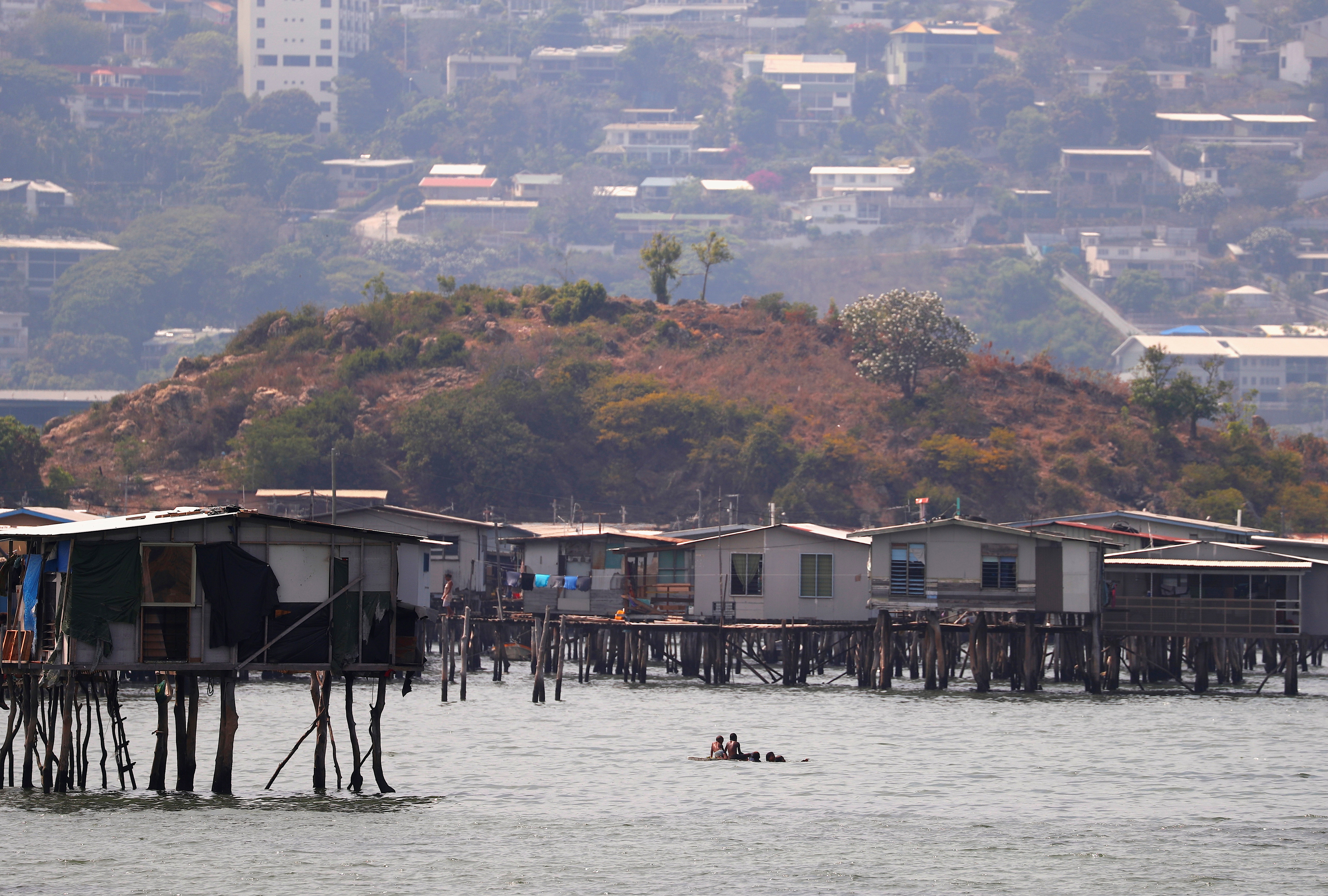 Newly constructed apartment blocks are seen behind the stilt house village called Hanuabada, located in Port Moresby Harbour, Papua New Guinea, November 19, 2018.