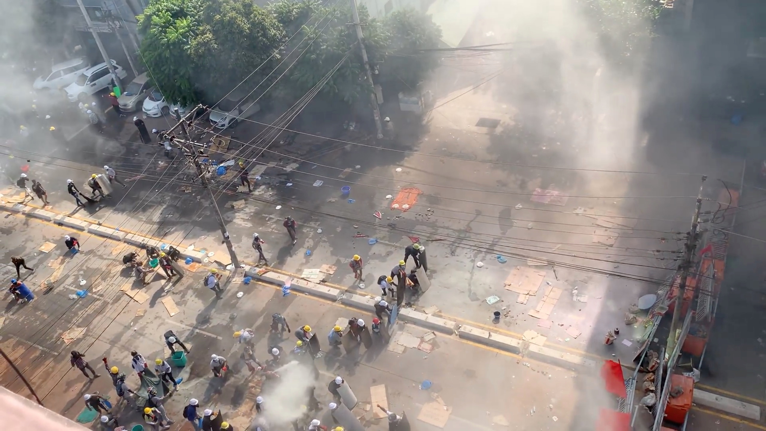 Demonstrators are seen behind makeshift barricades during a protest in Yangon on Thursday