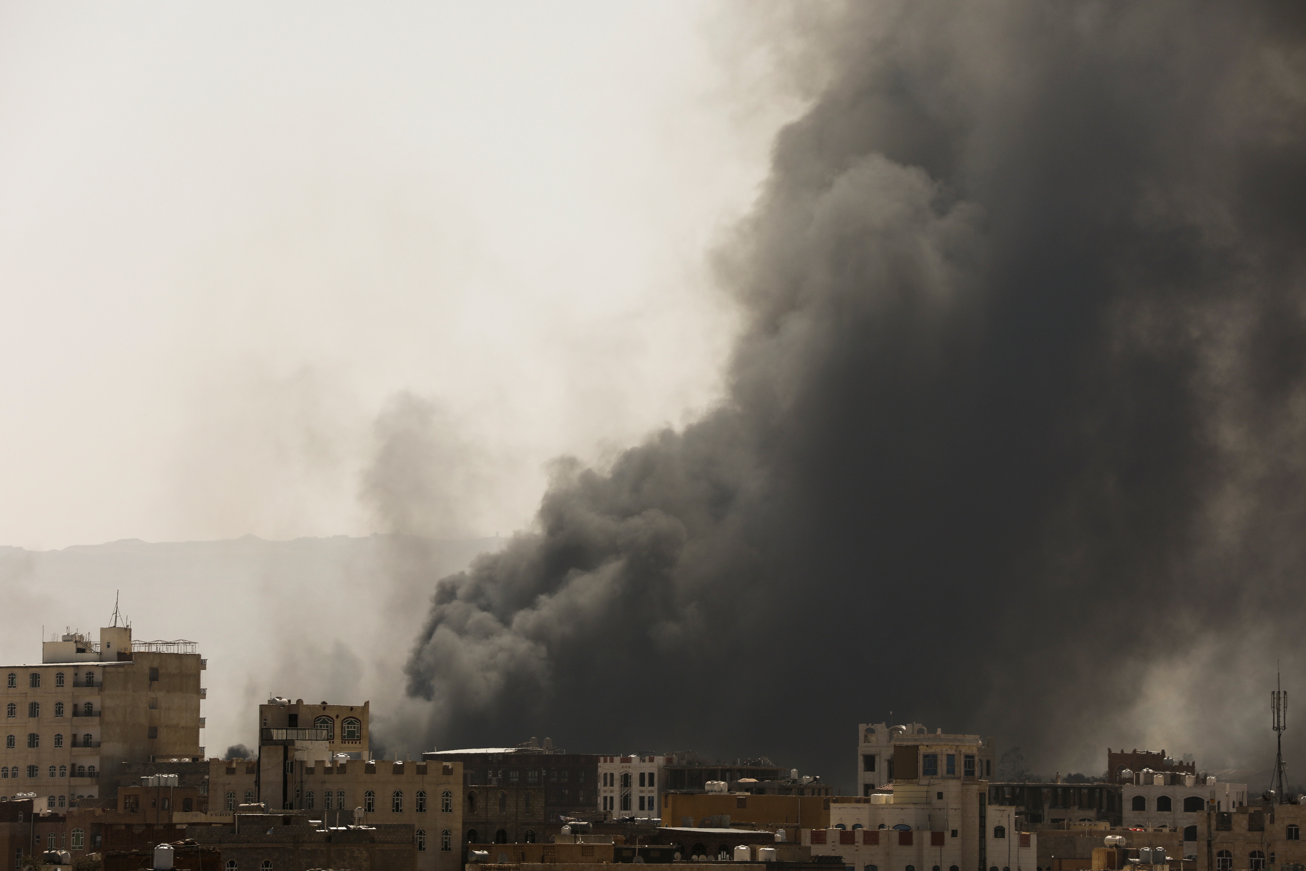 Smoke and dust rise near buildings from air strikes launched by Saudi-led coalition on Sanaa