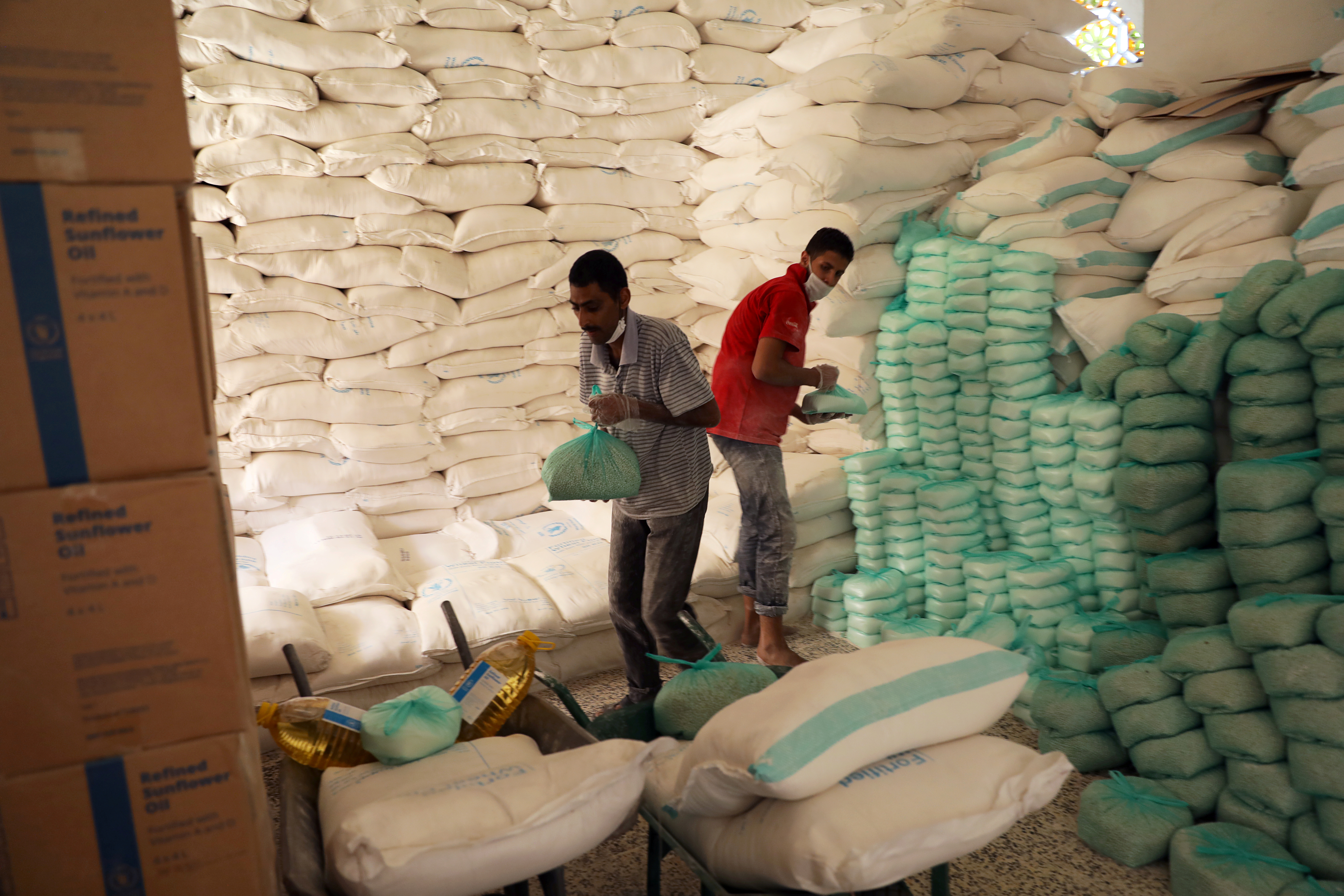 Workers stacking aid at a food distribution centre supported by the World Food Programme in Sanaa, Yemen