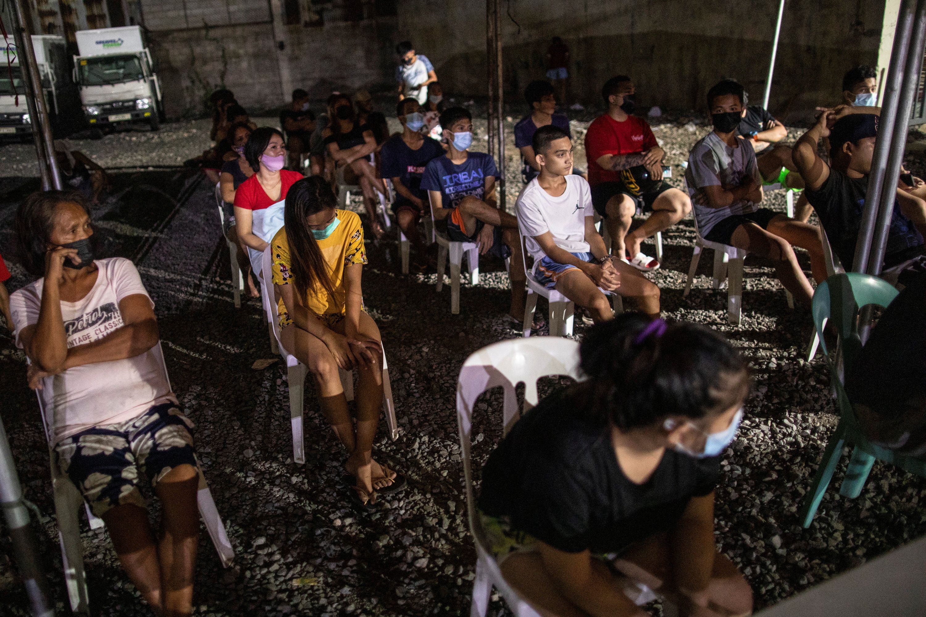 Curfew violators in Metro Manila are rounded up at a holding area as the government implements another curfew in the country’s capital amid a resurgence of COVID-19 cases