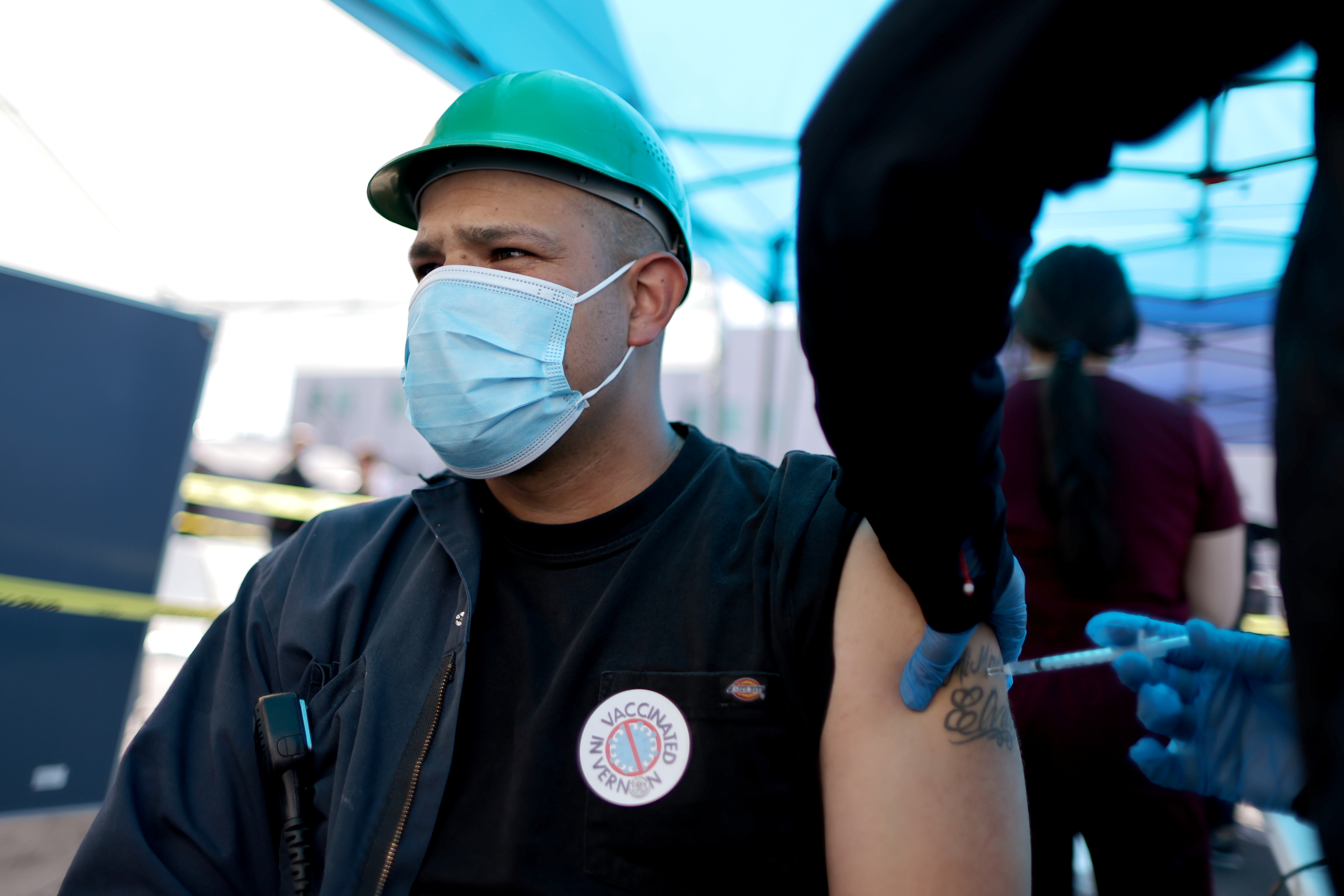 Luis Marquez, 33, receives a COVID-19 vaccine at a mobile vaccination drive for essential food processing workers in Los Angeles, California, in March