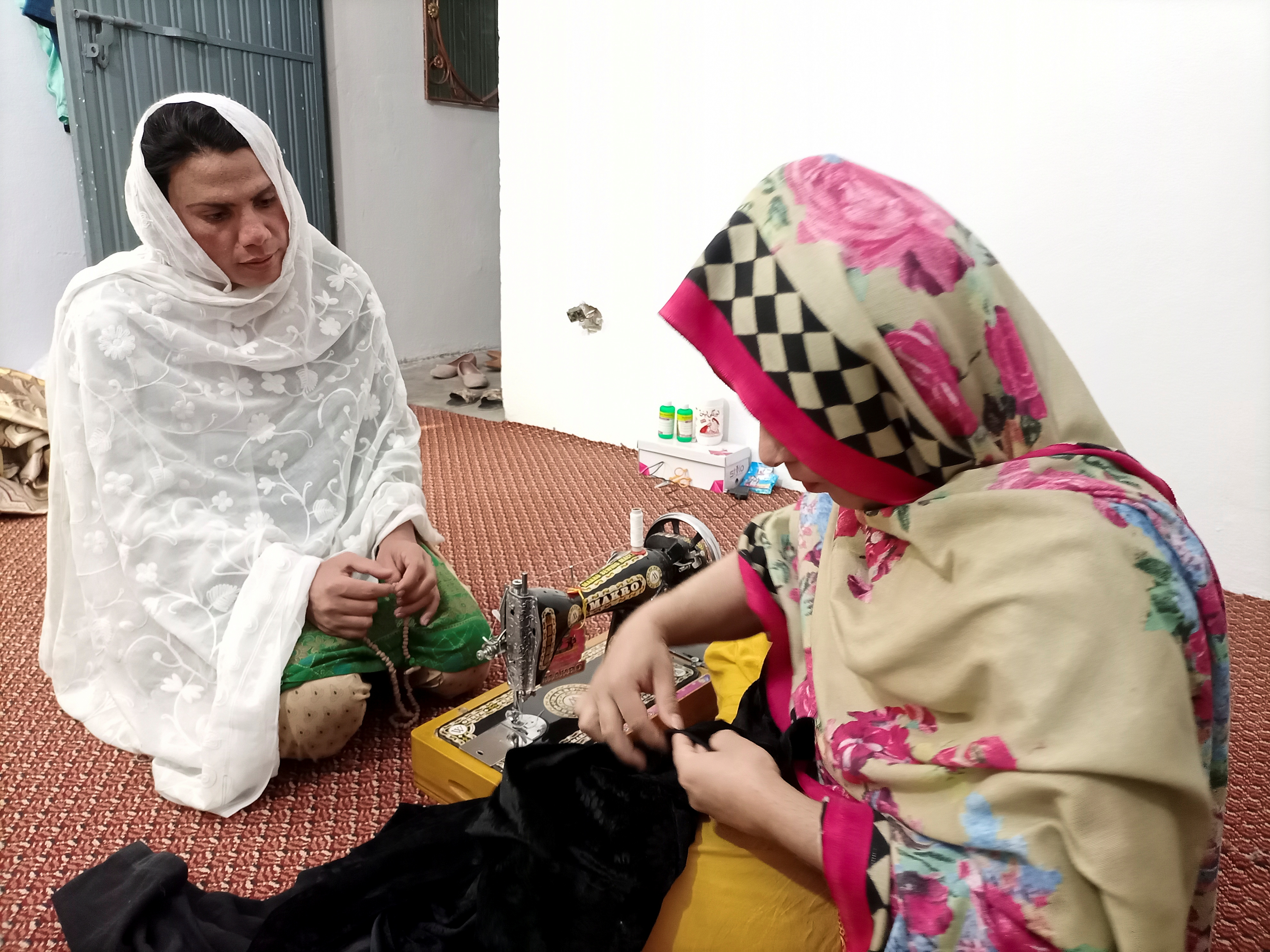 Rani Khan looks at one of her students during a sewing lesson