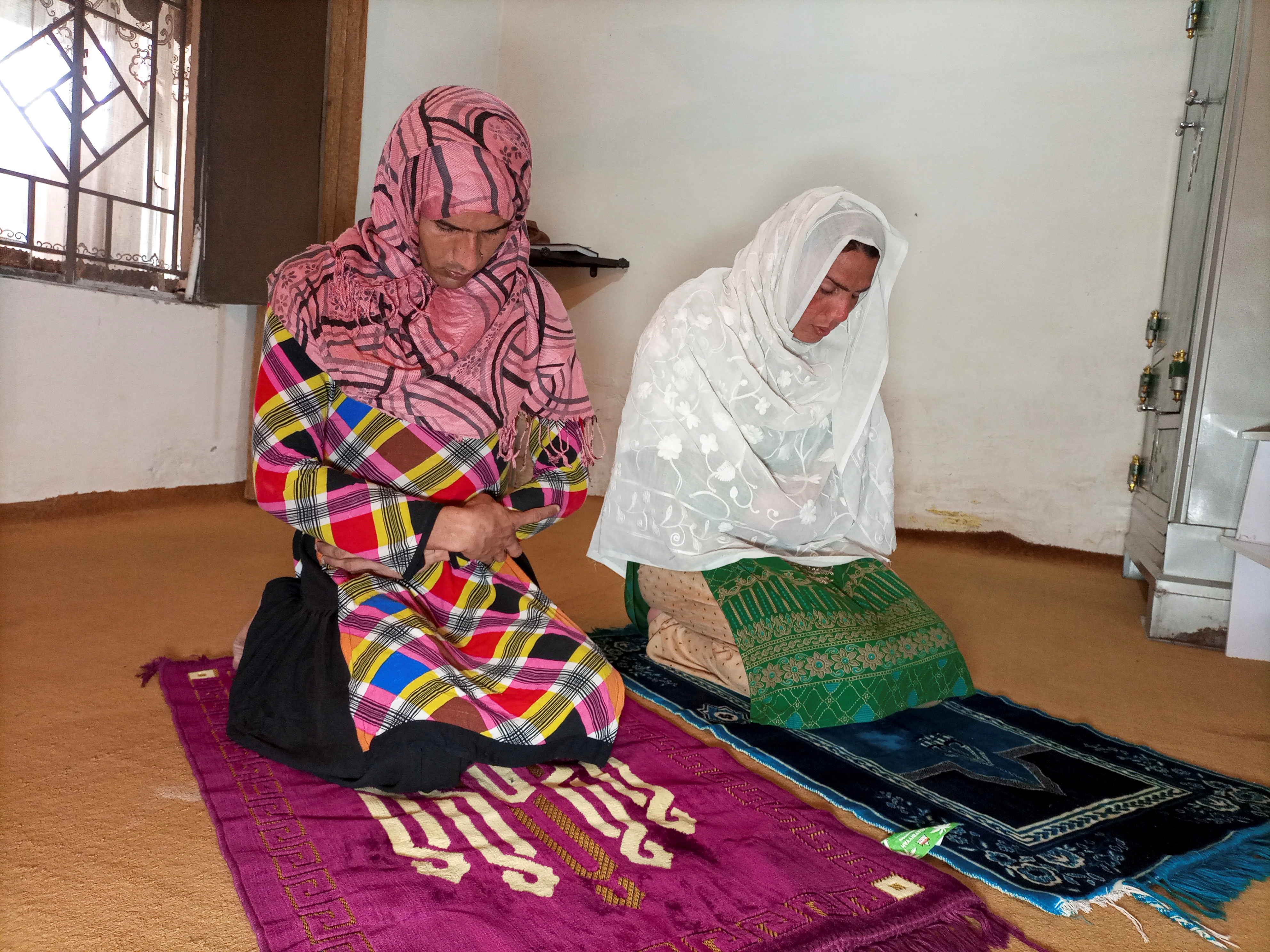 Rani Khan prays with one of her students