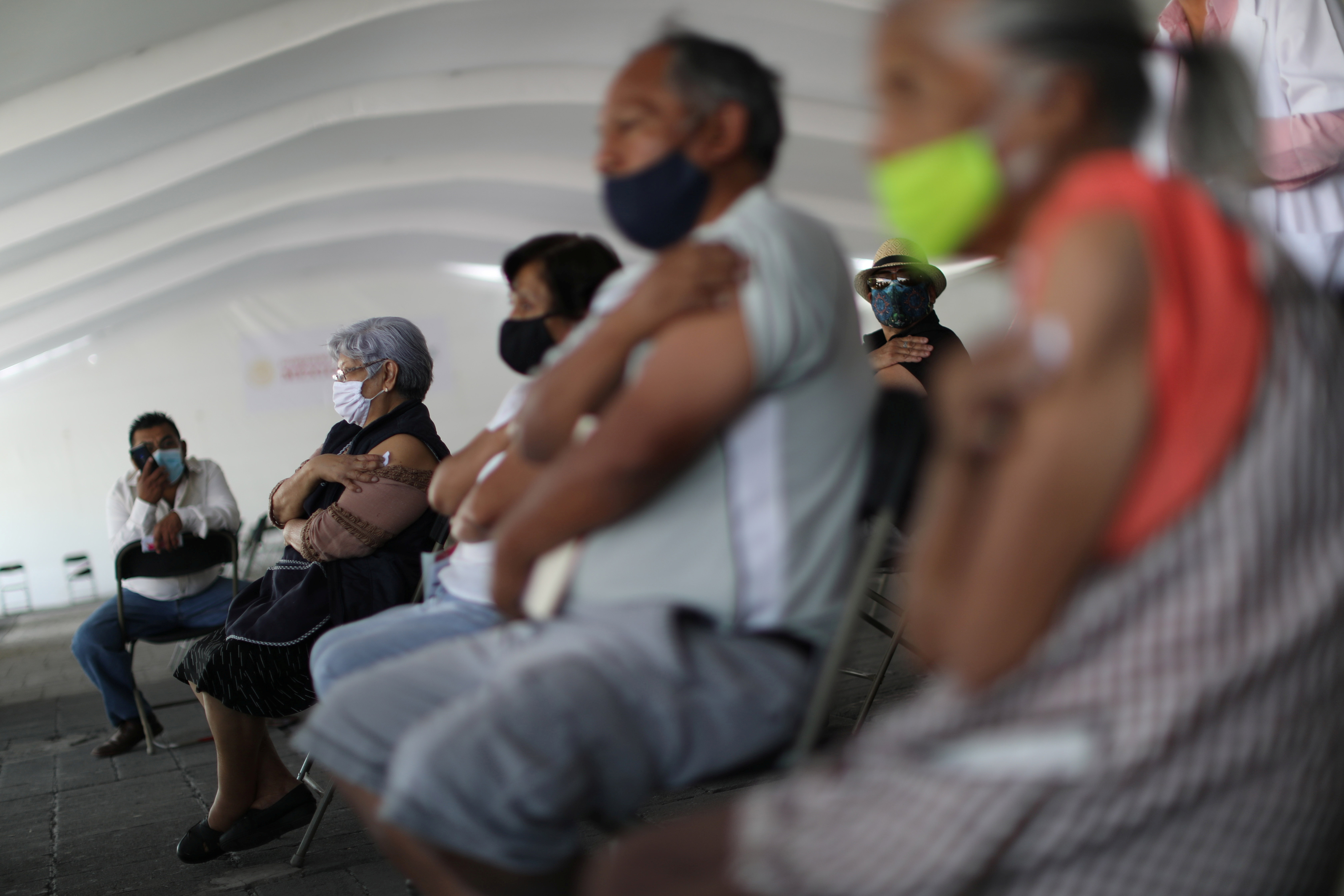 Elderly people sitting after having received a coronavirus vaccine at a mass vaccination site for elderly people in Mexico City, Mexico