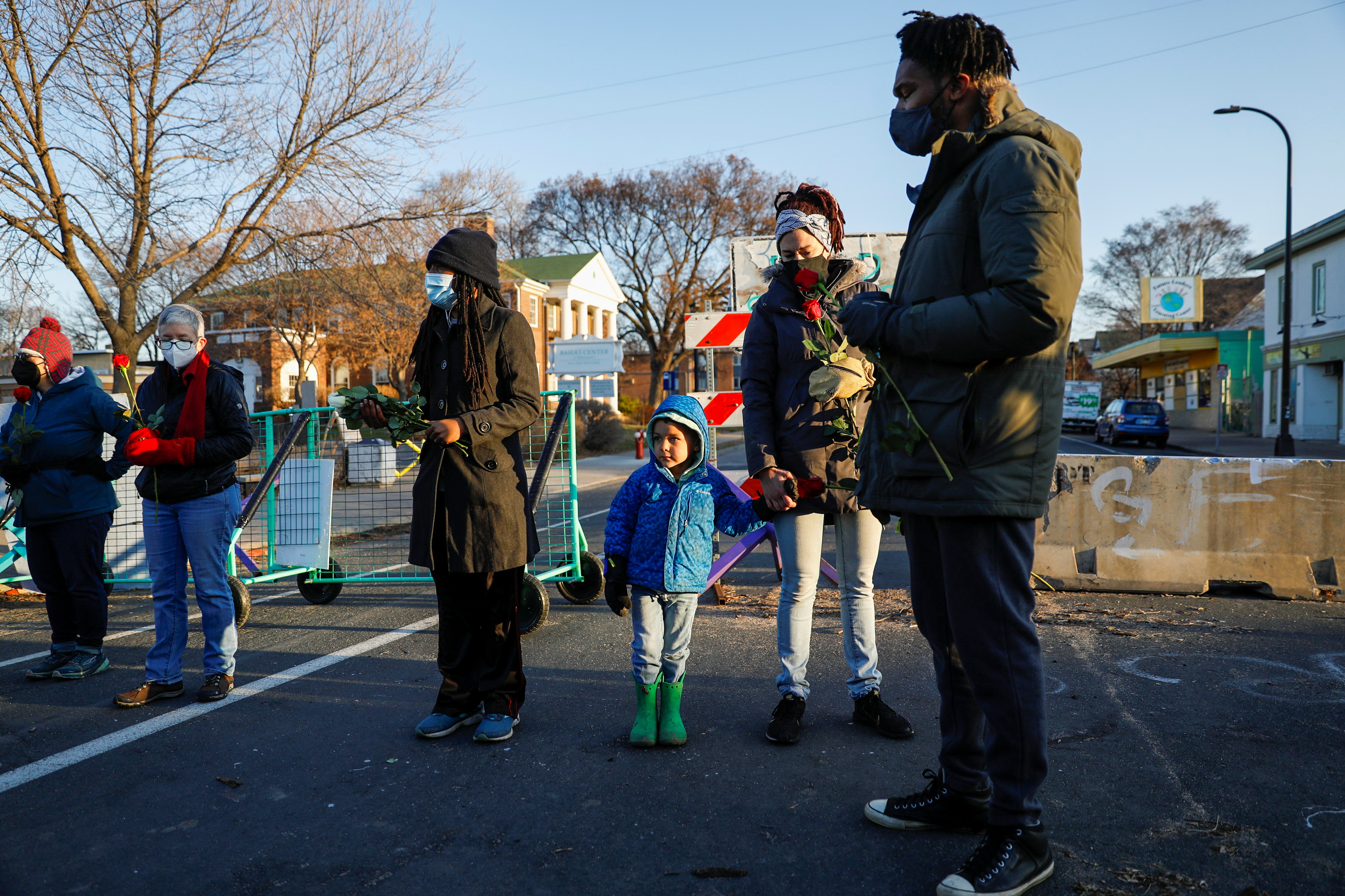 Community activist Jeanelle Austin stands with her sister-in-law Rachel Austin, brother Butchy Austin, and his son Mateo during a prayer walk near George Floyd Square, on the day of opening statements in Chauvin’s trial in Minneapolis