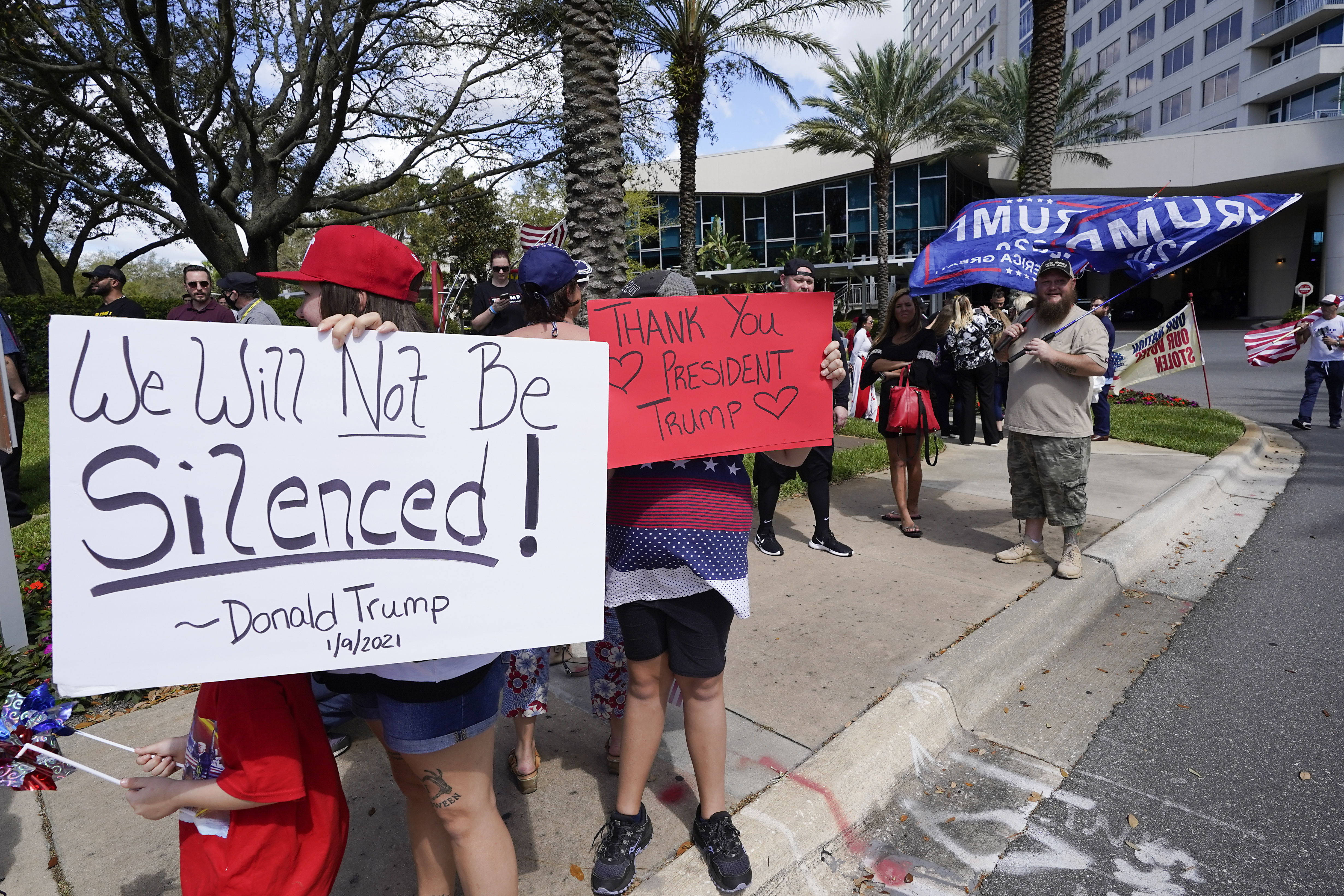 Trump supporters hold signs and wave to motorists outside the convention centre at the Conservative Political Action Conference in Orlando, Florida