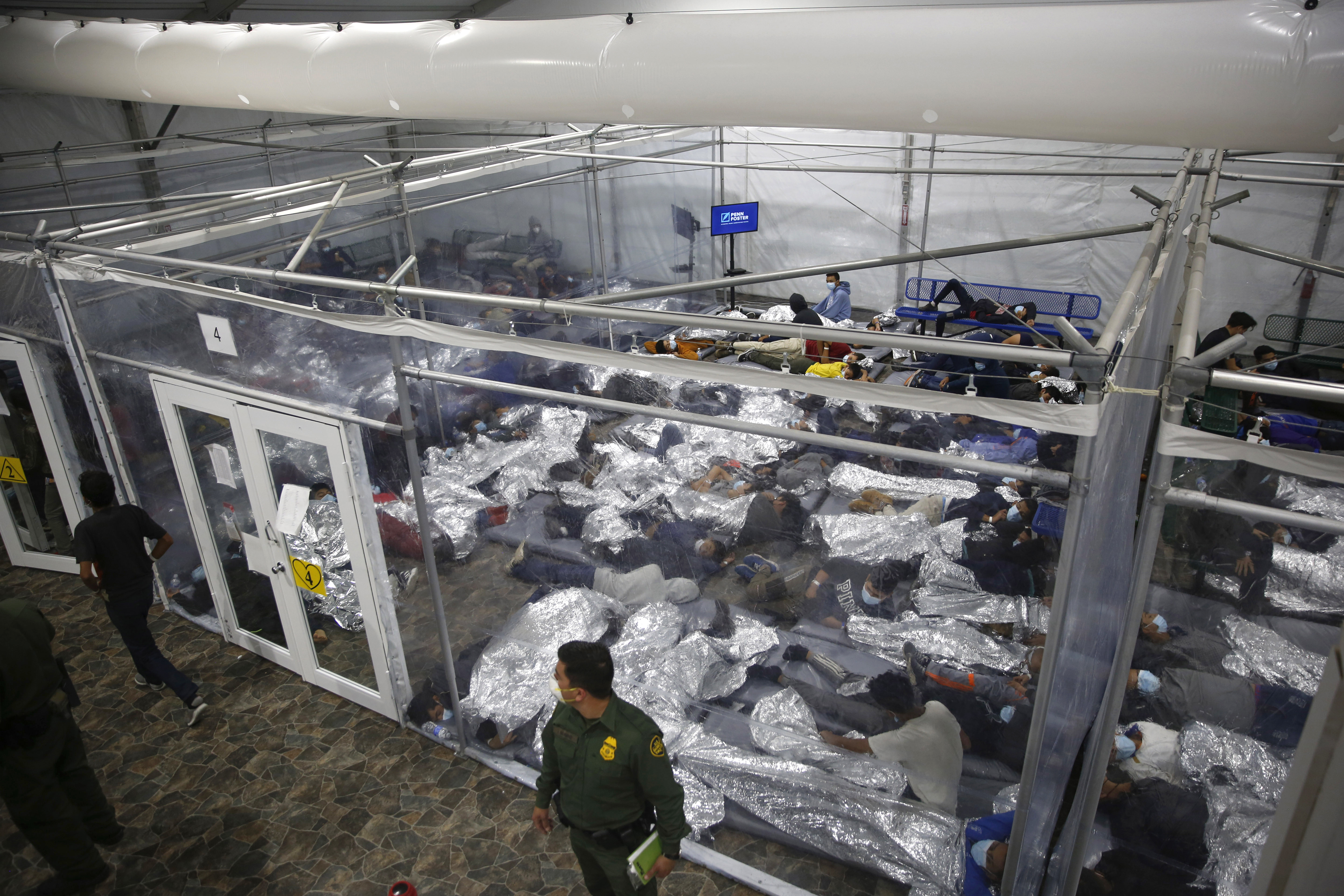 Young migrants are held in a fenced off area