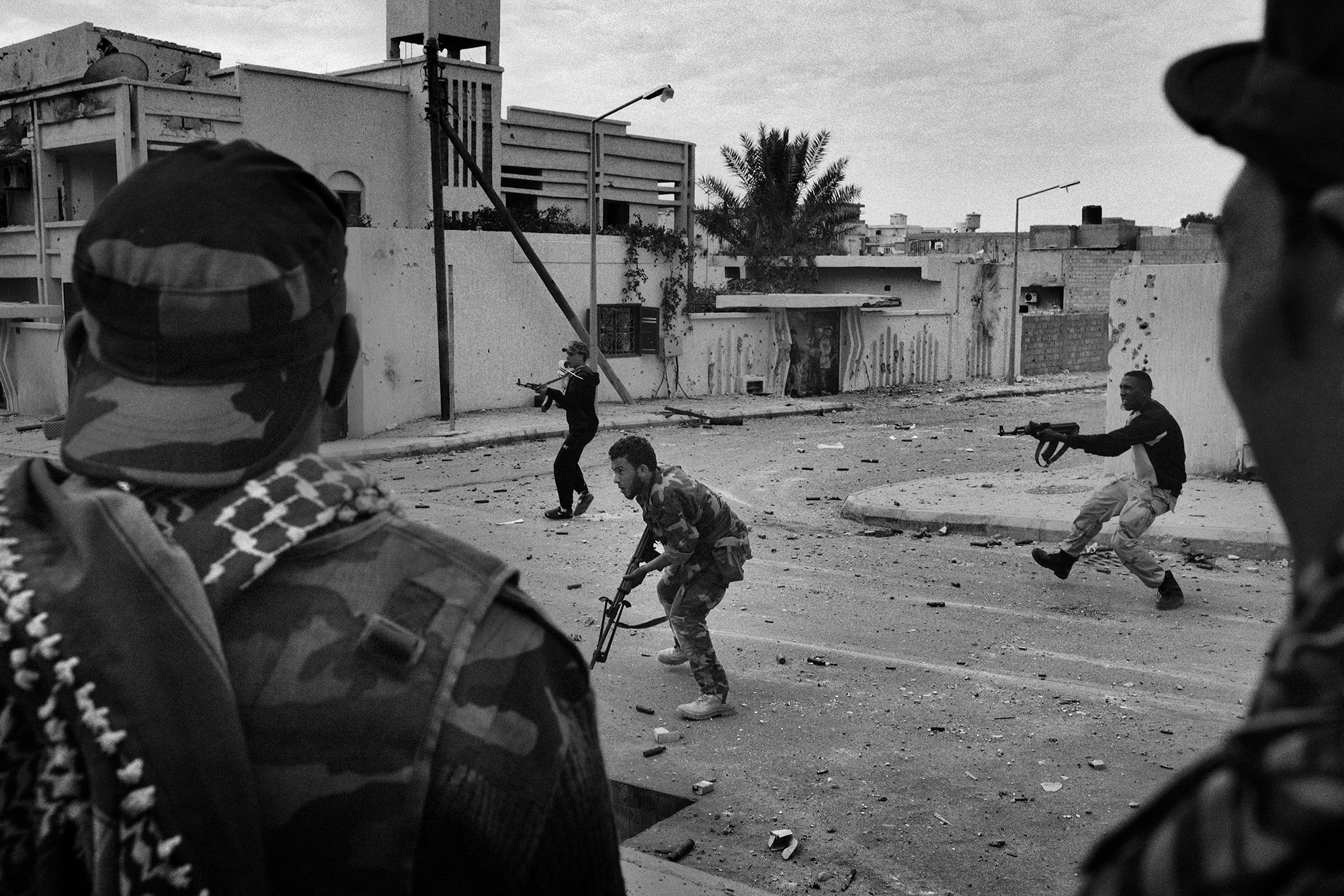 Anti-Gaddafi fighters from Benghazi engage in a firefight with snipers who are loyalists to Colonel Muammar Gaddafi during a street fight in Gaddafi's hometown of Sirte, Libya, on October 19, 2011 [Mauricio Lima]