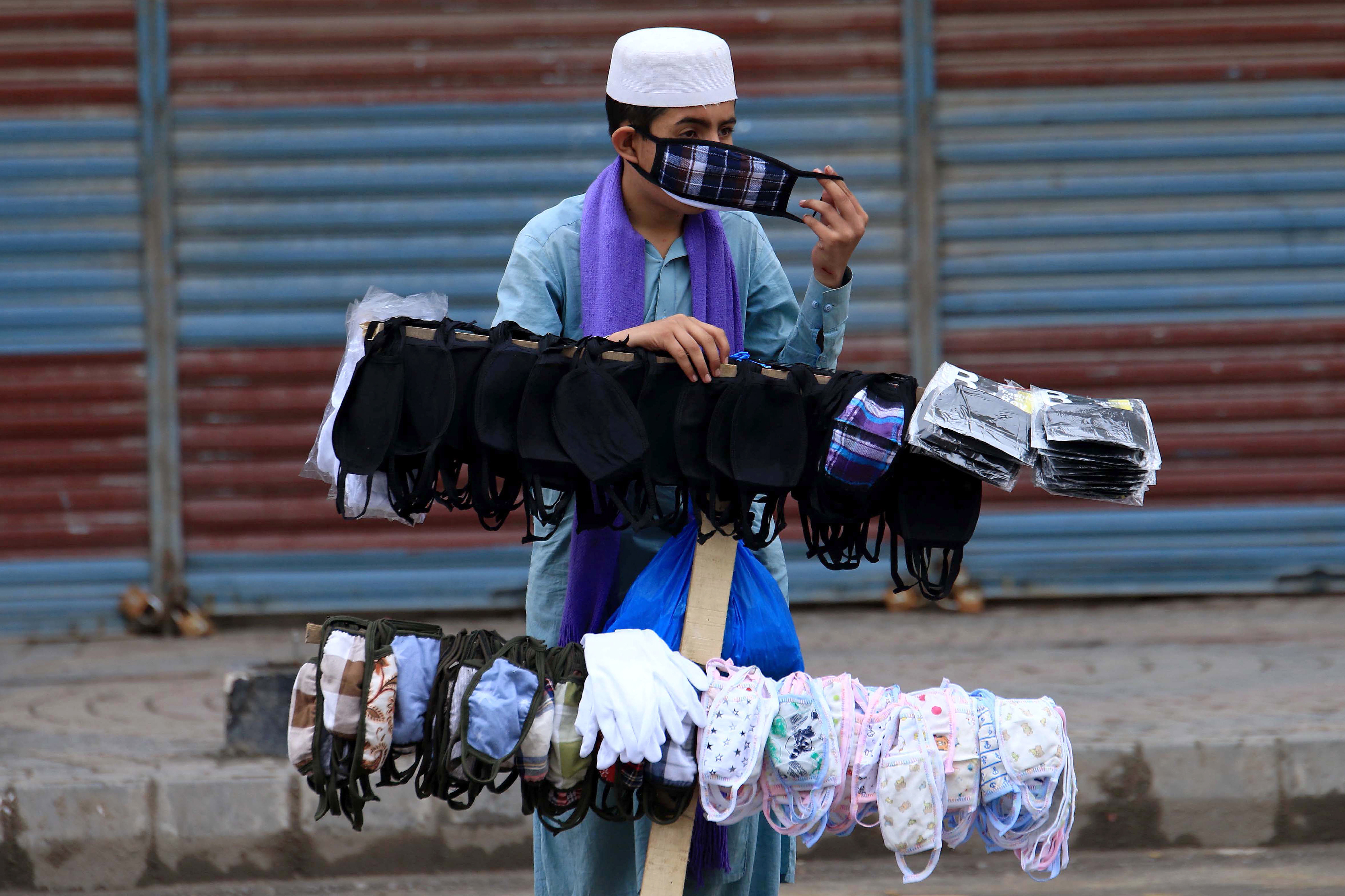 A boy sells protective masks in Peshawar after a spike in COVID cases across Pakistan