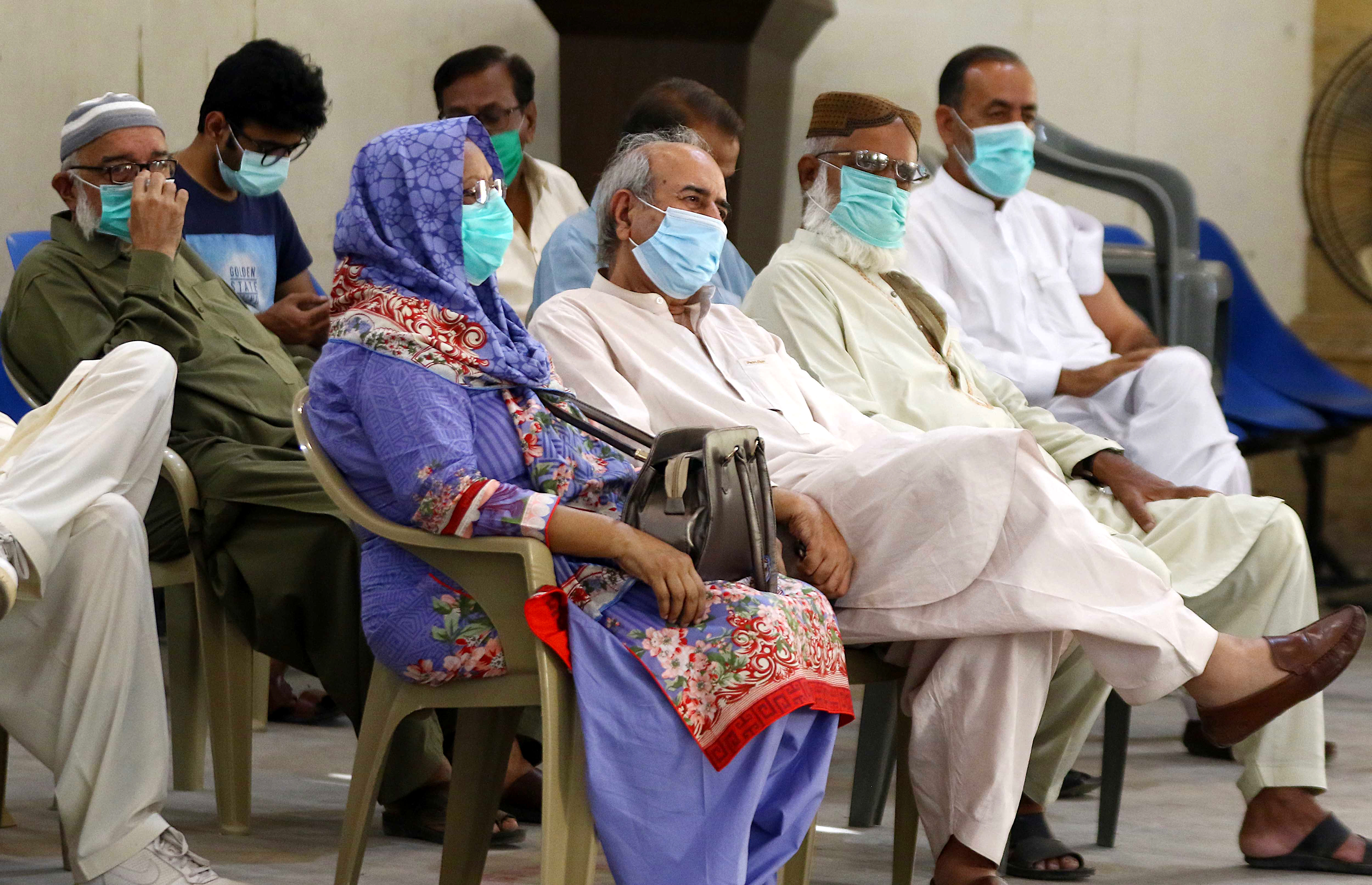 Senior citizens wait to receive COVID vaccines in Karachi