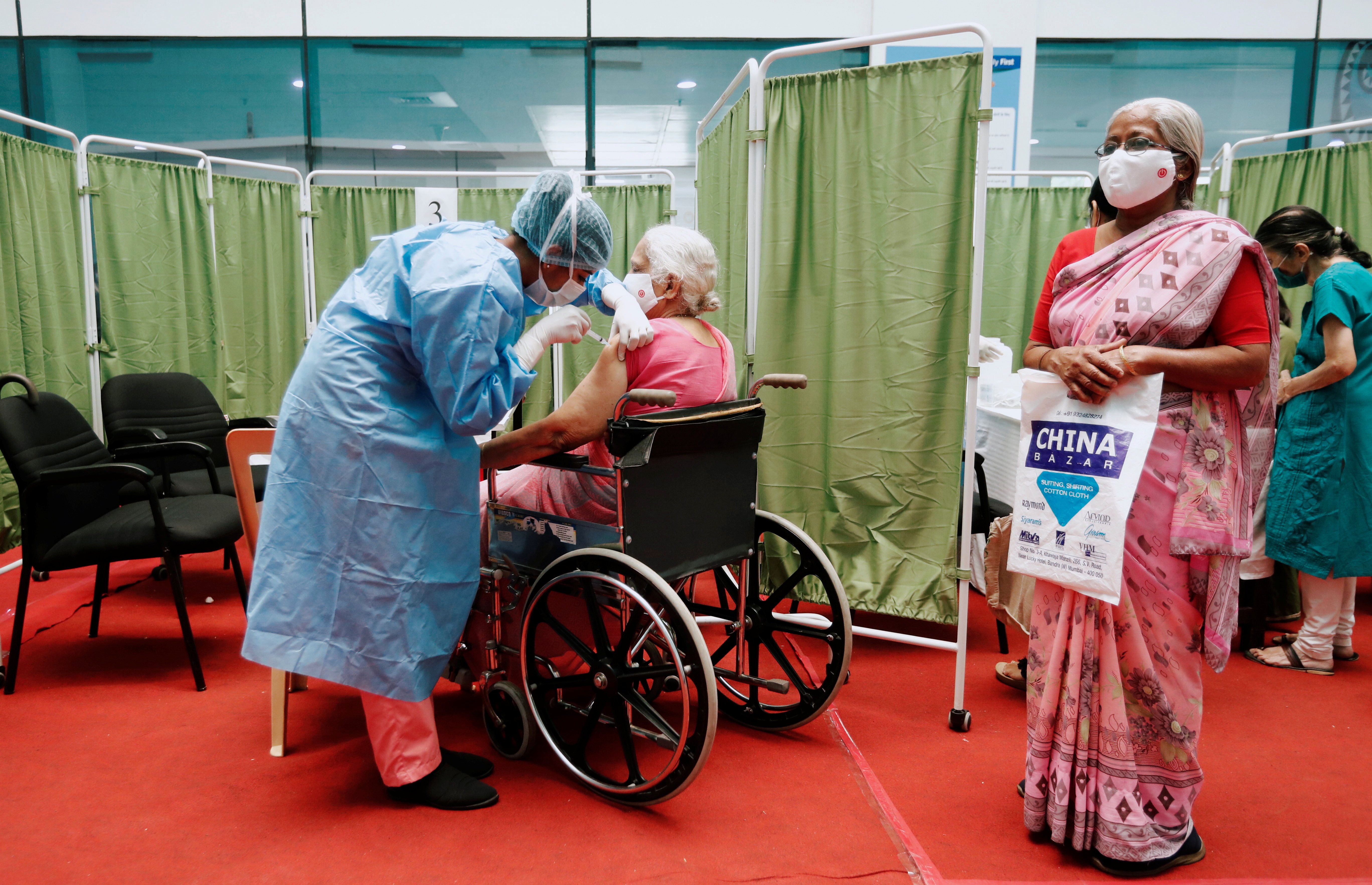 A woman in a wheelchair receives a dose of Covishield, a COVID-19 vaccine being manufactured by the Serum Institute of India, in Mumbai, India
