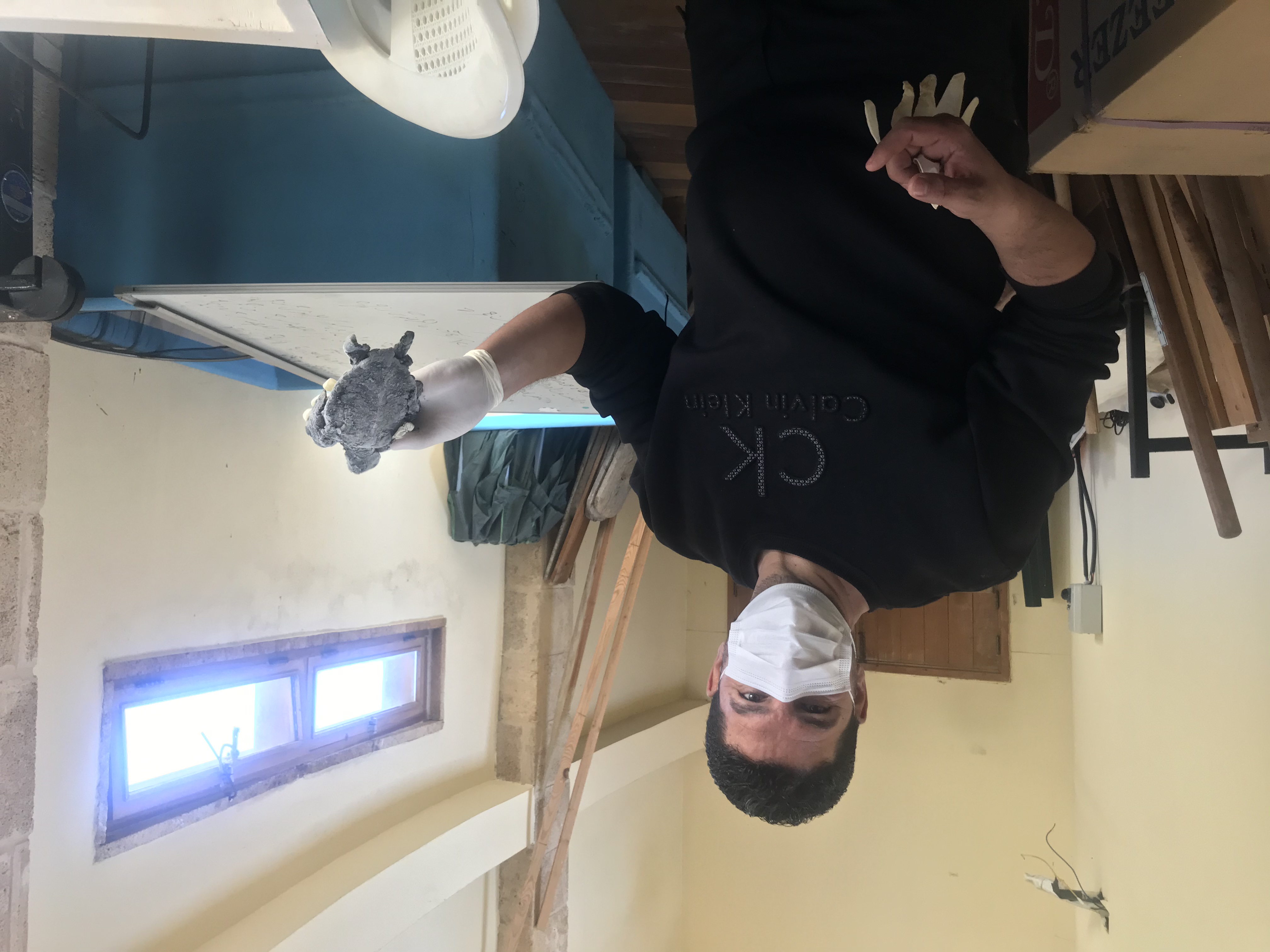 Hassan Hamze holds up a turtle killed by the oil spill