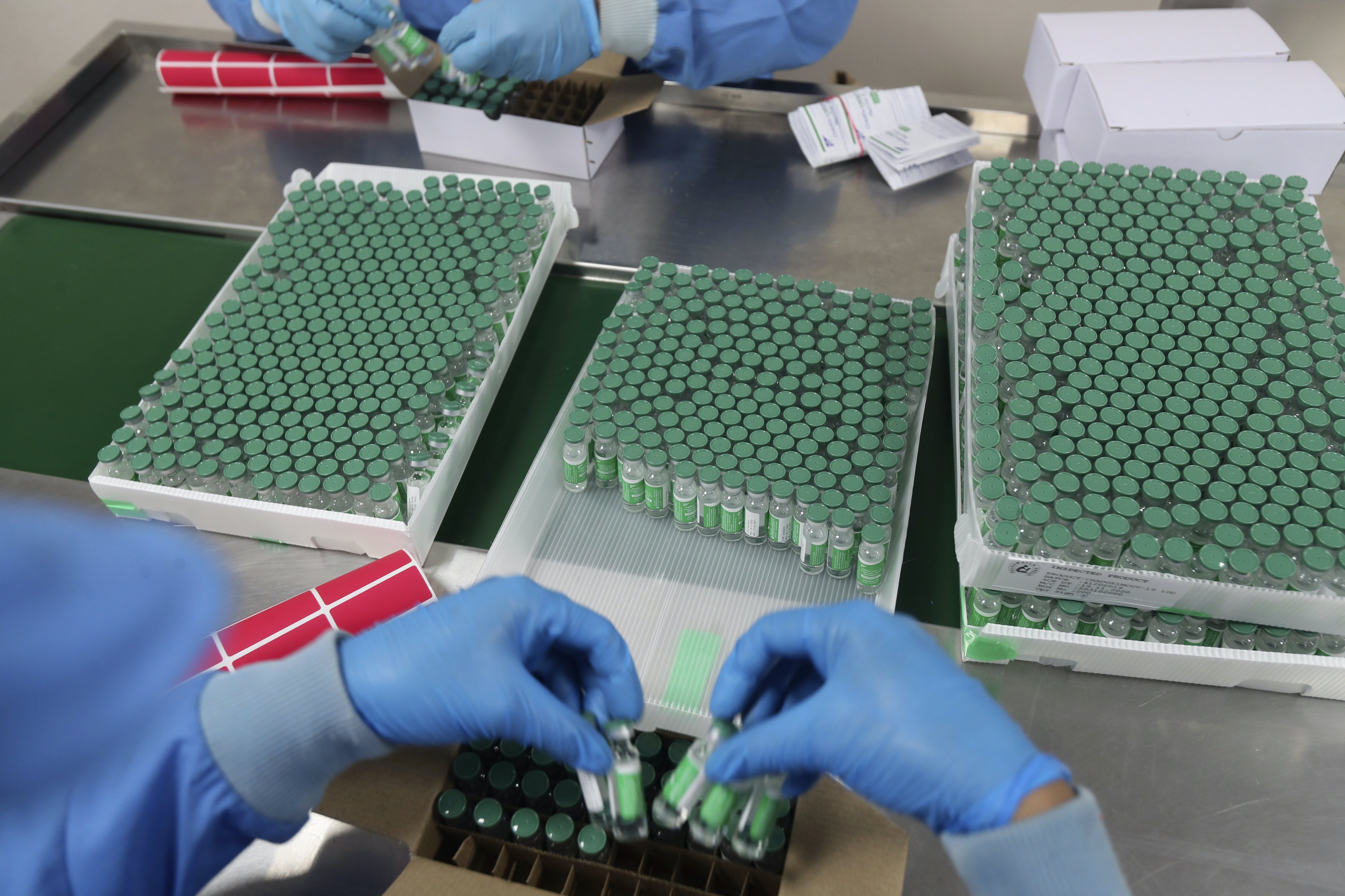 Employees pack boxes containing vials of AstraZeneca’s Covishield coronavirus vaccine at the Serum Institute of India, in Pune, India