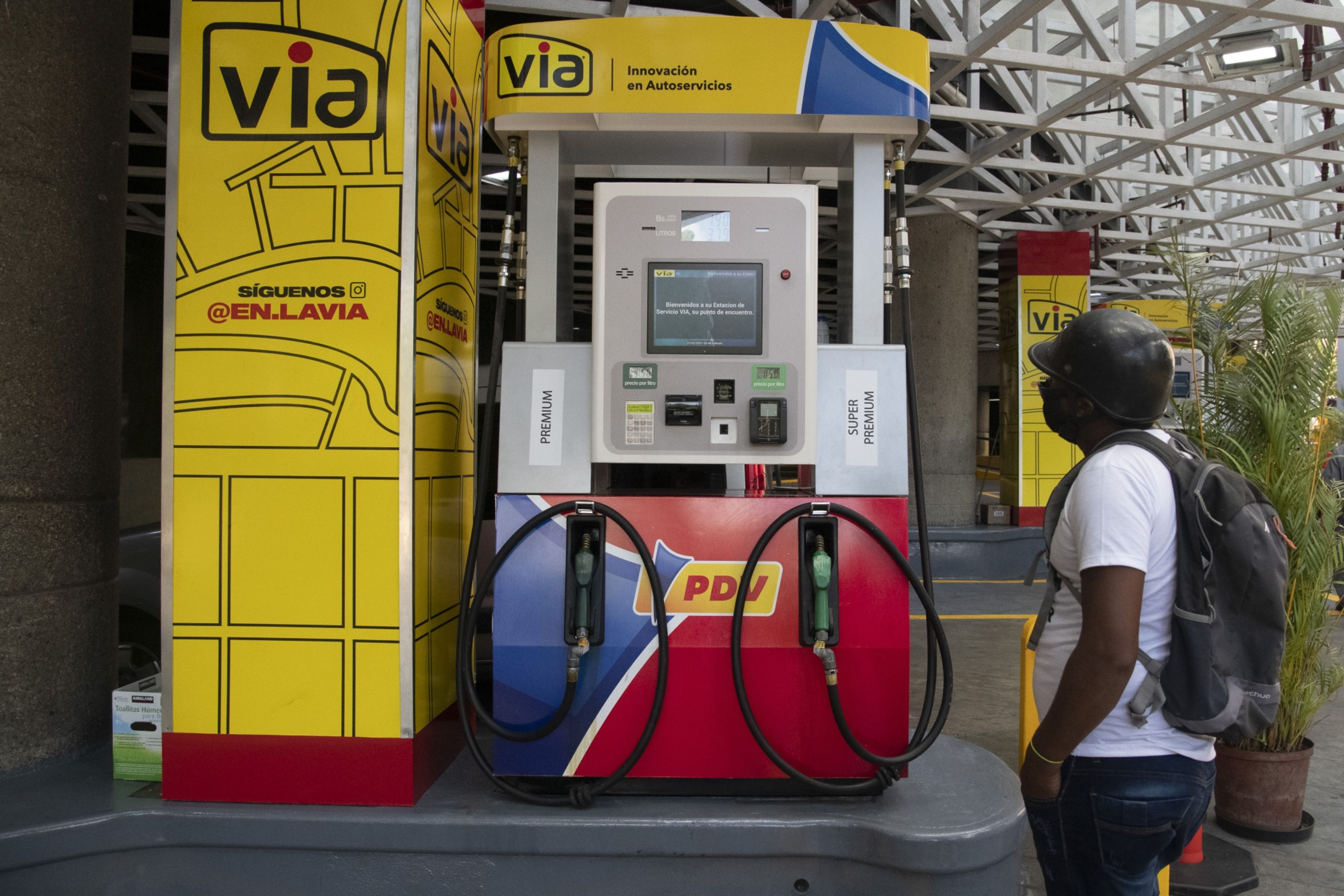 A person looks at a new fuel pump at a VIA Petroleos de Venezuela SA (PDVSA) gas station in Caracas, Venezuela