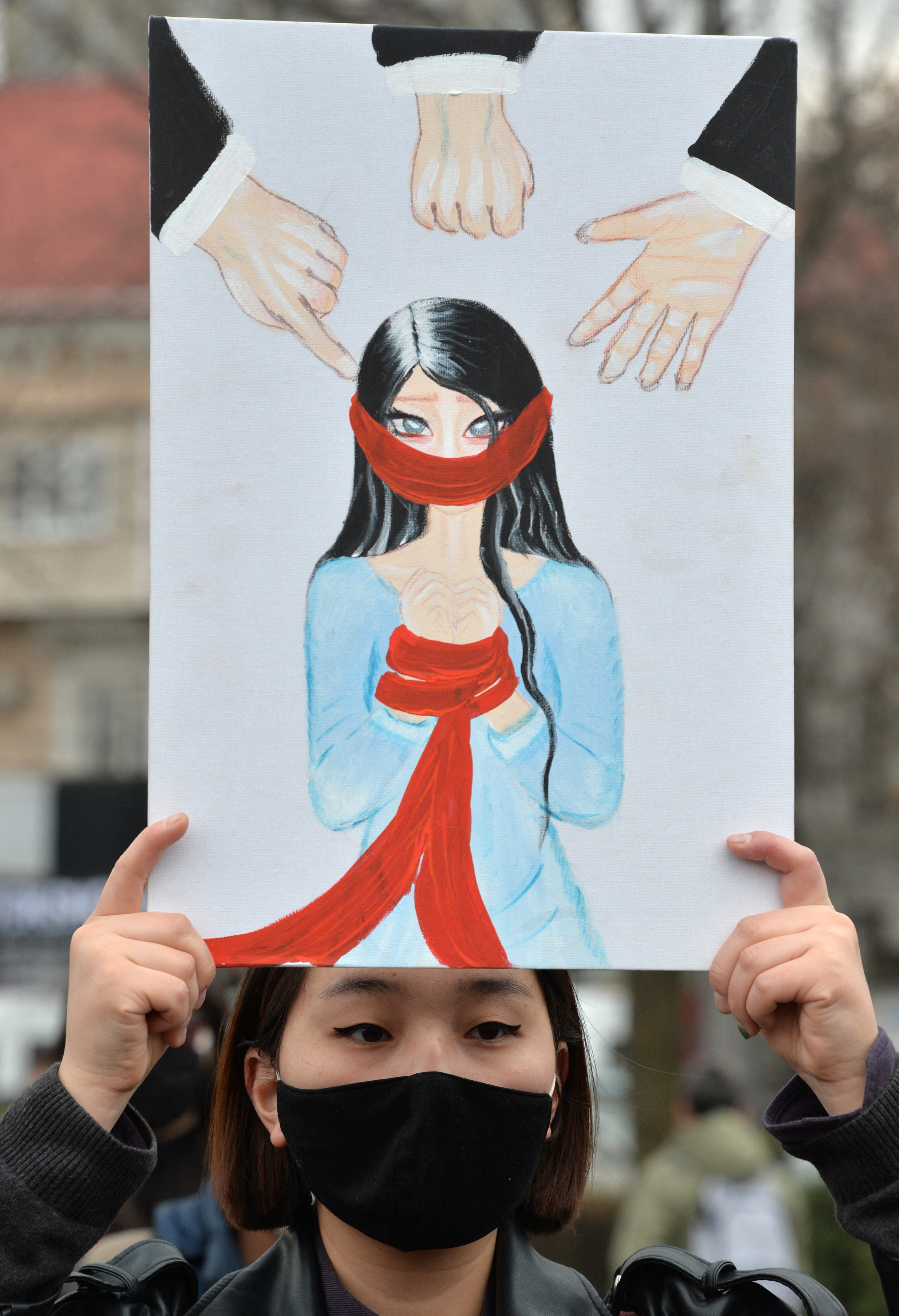 A woman holds a poster during a rally