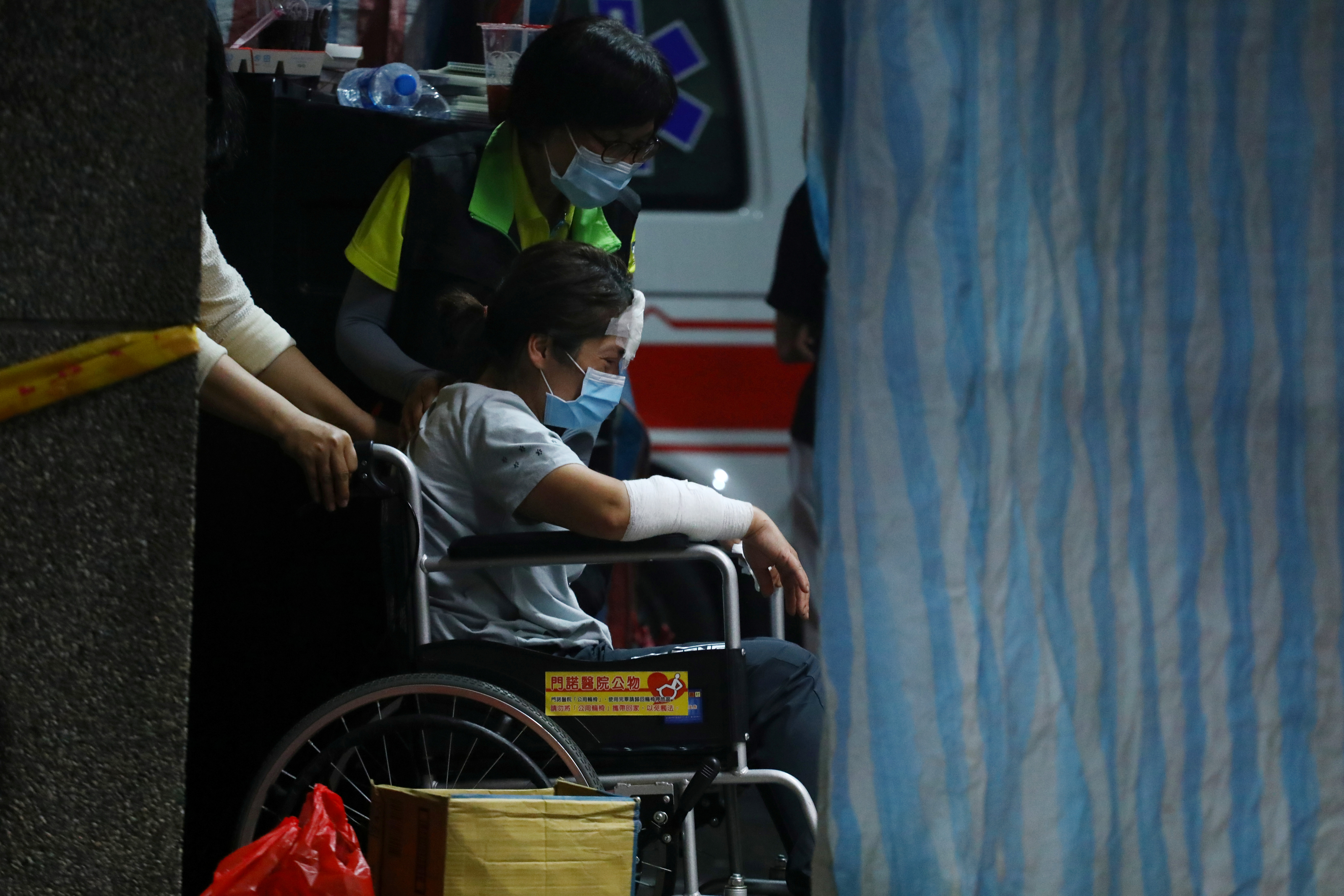 A wounded family member enters the morgue for body identification, at a funeral parlour after a deadly train derailment in Taiwan on Friday