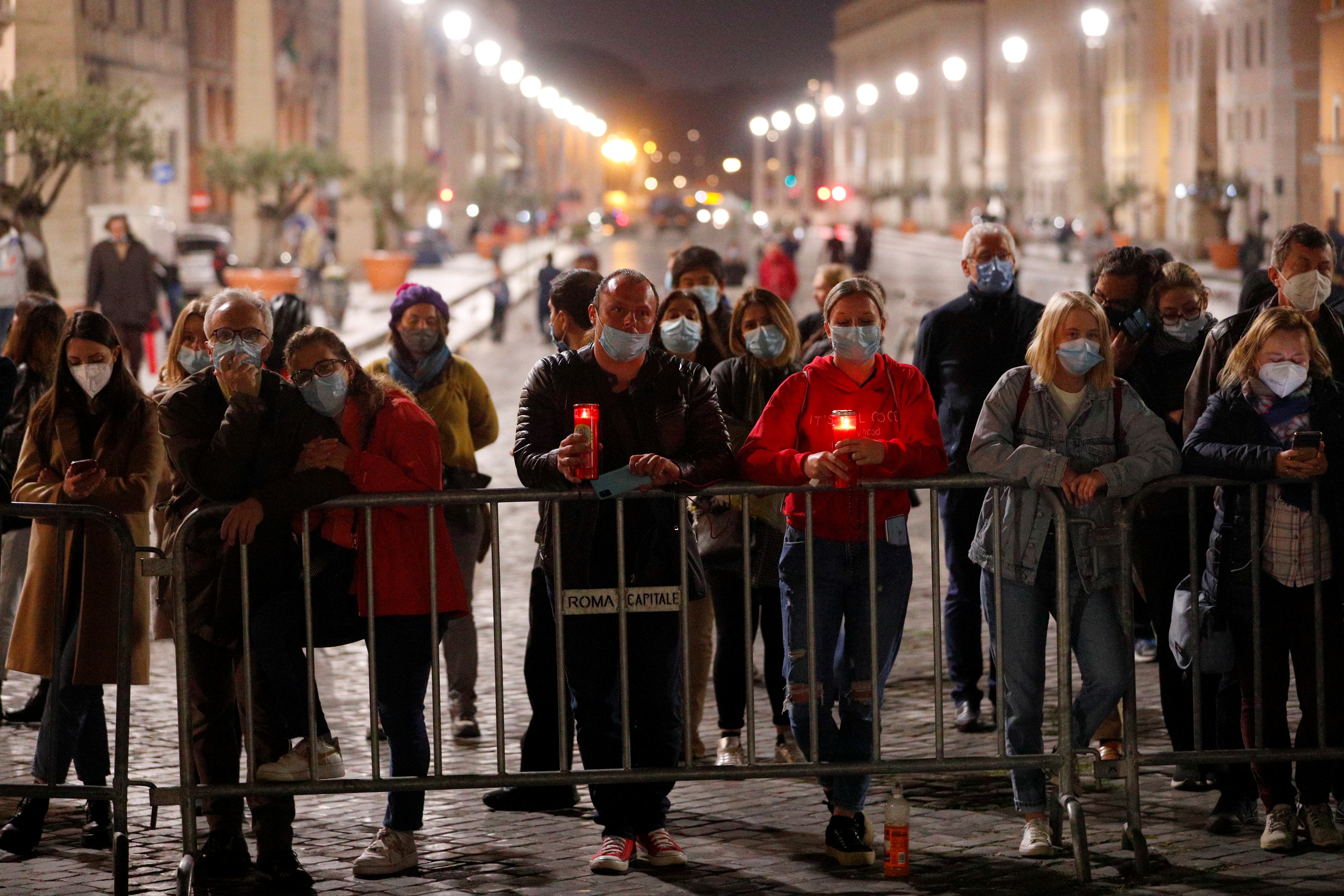 A limited number of worshippers, due to COVID restrictions, watch the Via Crucis (Way of the Cross) procession led by Pope Francis in St Peter’s Square, Vatican City, during Good Friday celebrations