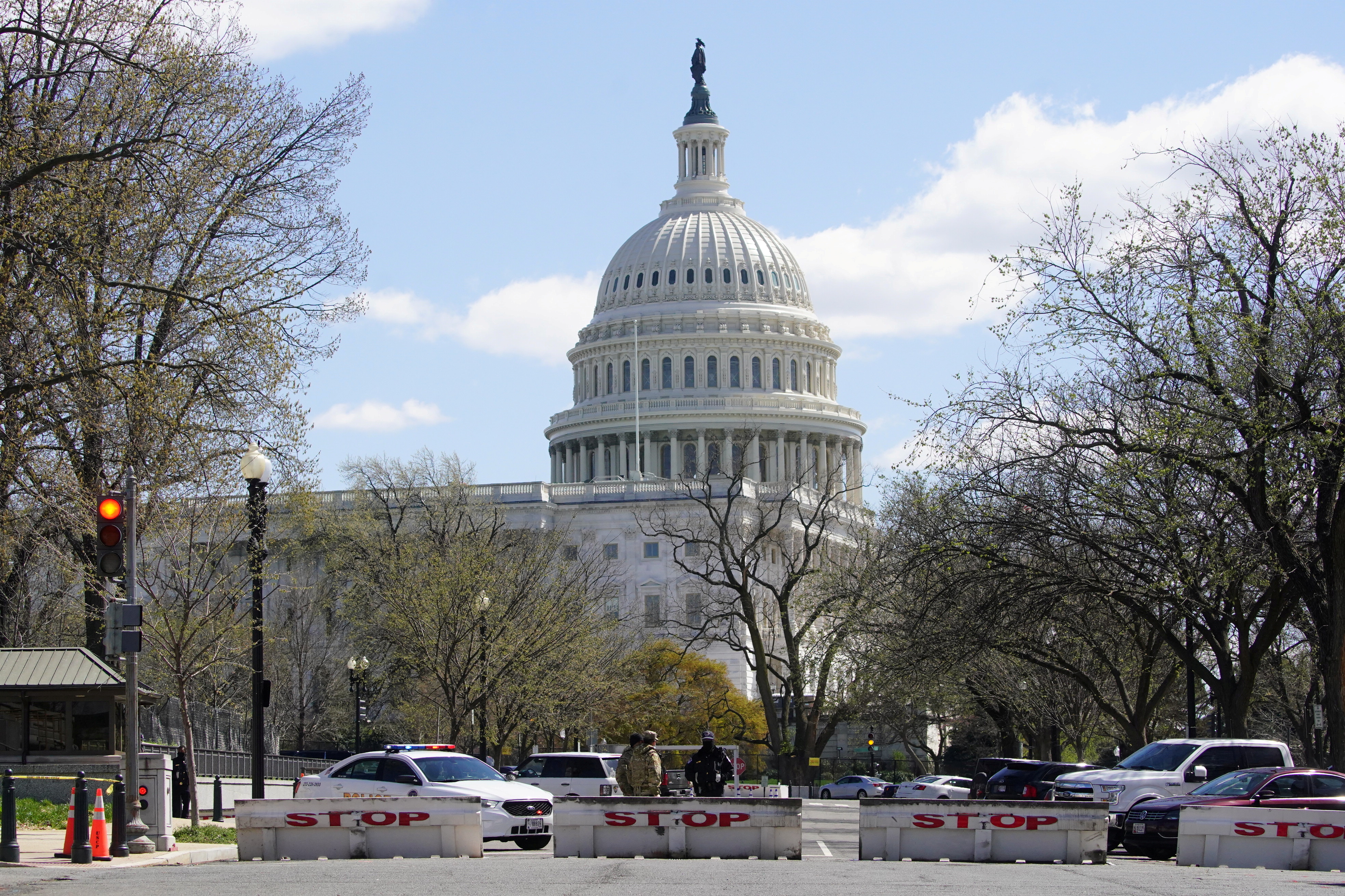 Police and National Guard officers stand watch in streets surrounding the US Capitol following a vehicular attack that killed one officer and wounded another on April 2, 2021