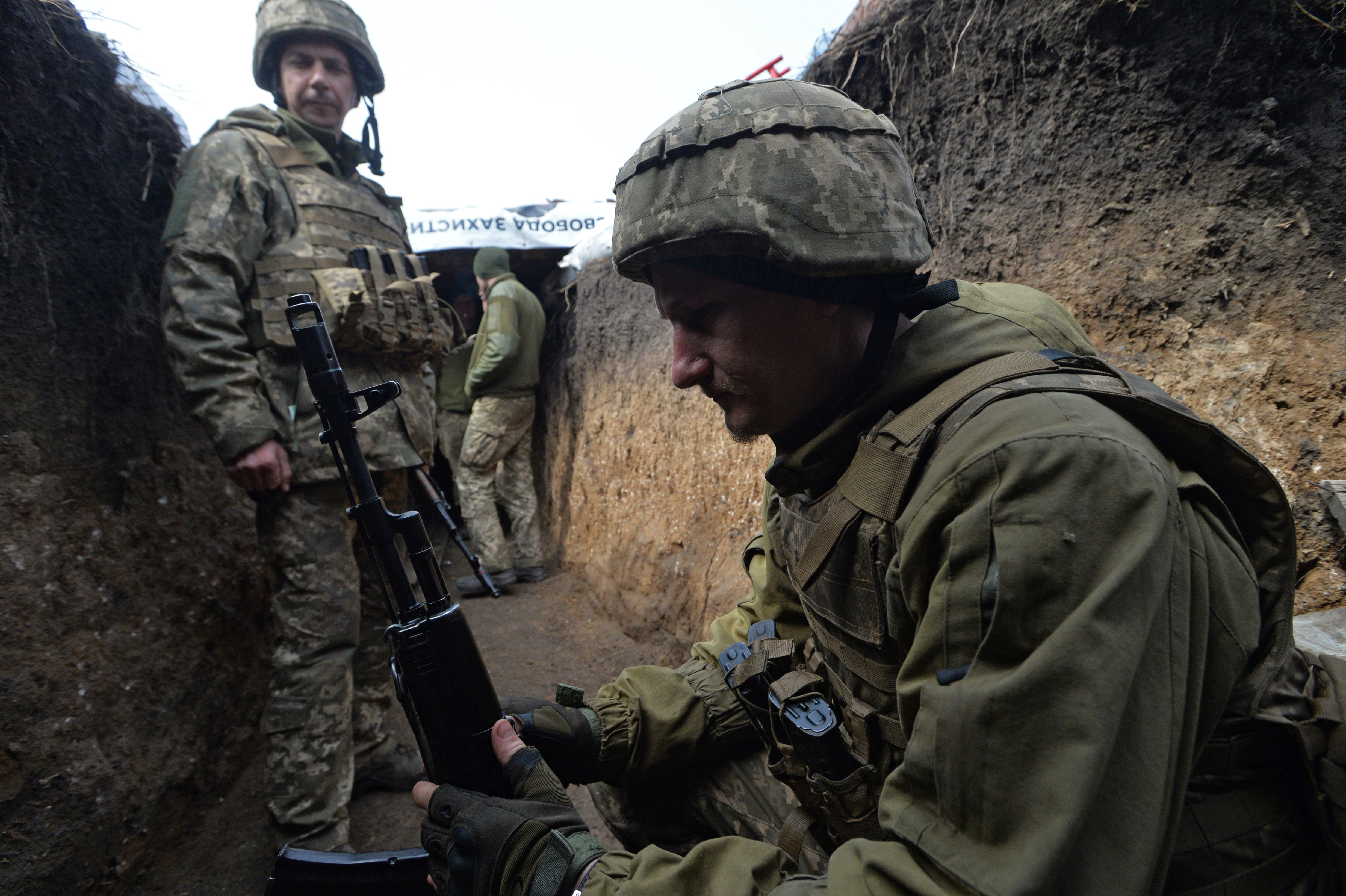 Service members of the Ukrainian armed forces at fighting positions on the line of separation in the village of Pisky, Donetsk region
