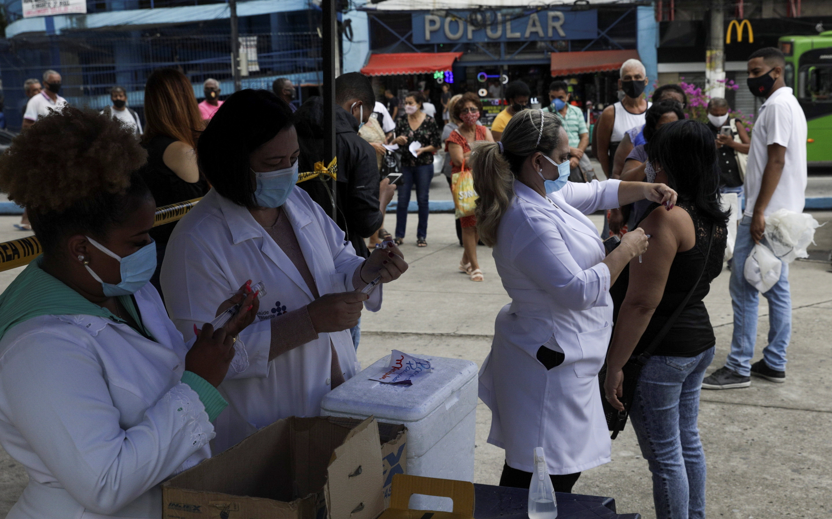 A woman receiving a dose of the AstraZeneca vaccine, during a vaccination day campaign in Duque de Caxias near Rio de Janeiro, Brazil