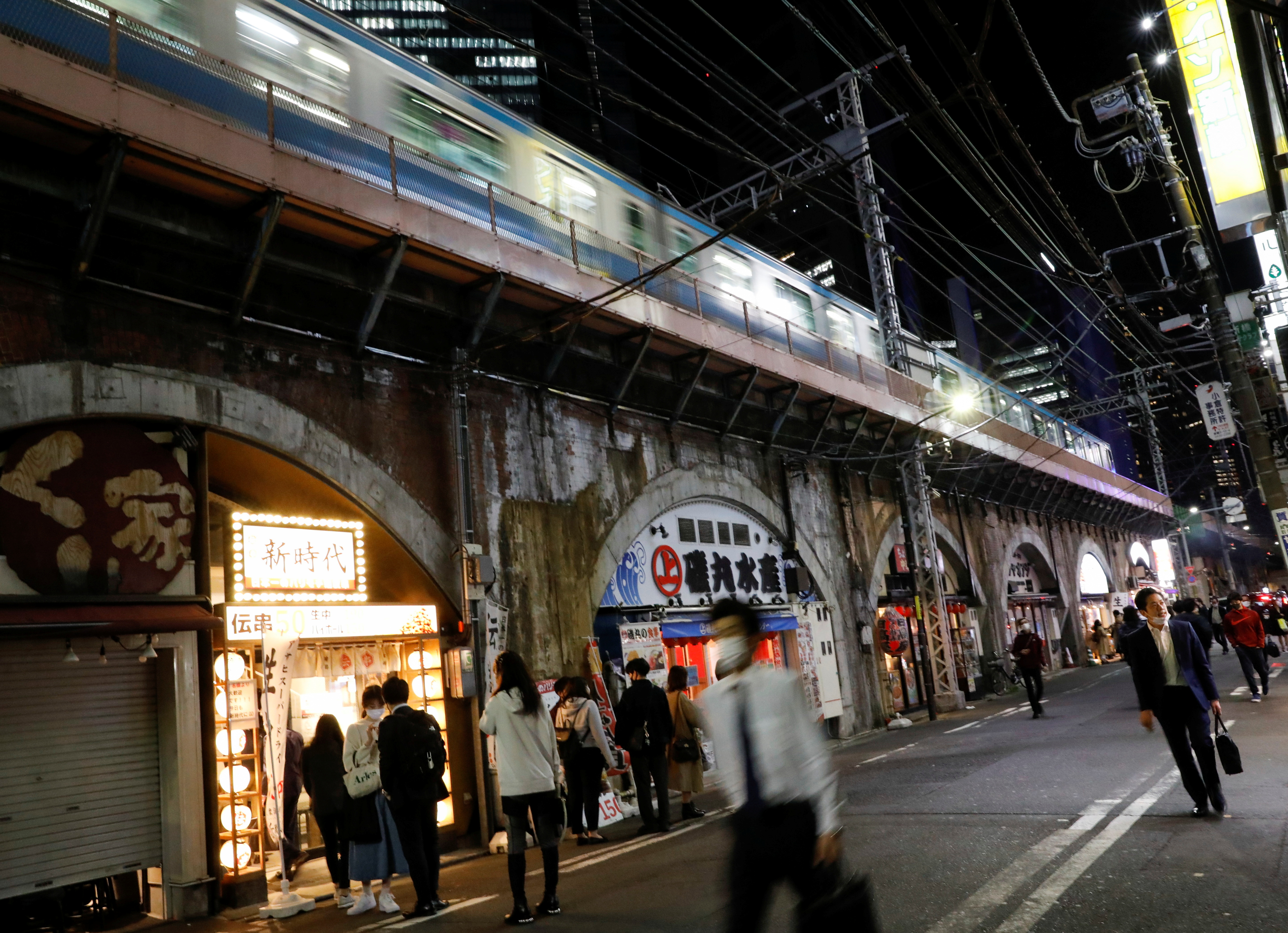 People wearing protective masks walk on the street in Tokyo