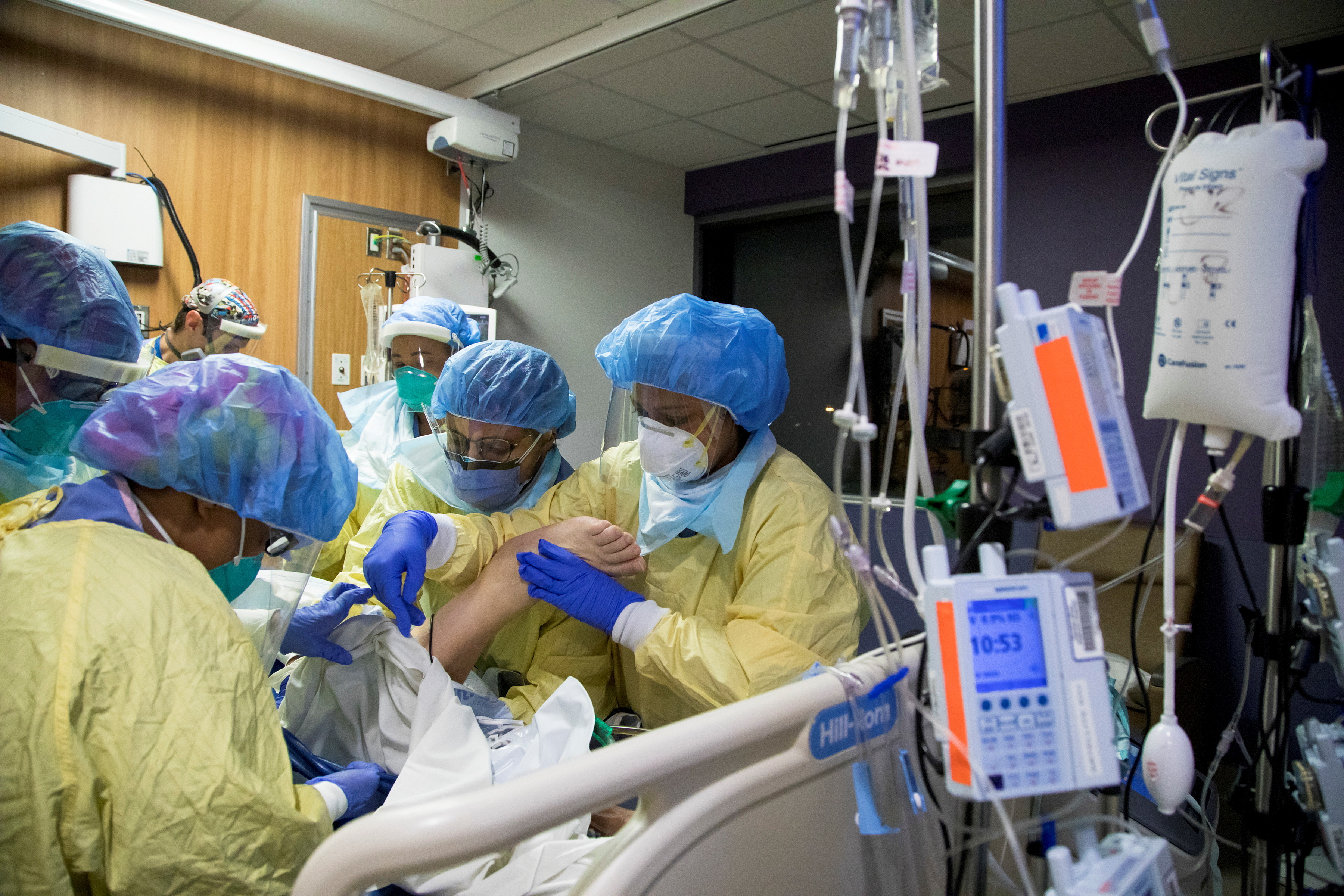 A respiratory therapist and six nurses move a COVID-19 patient inside the intensive care unit of Humber River Hospital in Toronto, Ontario