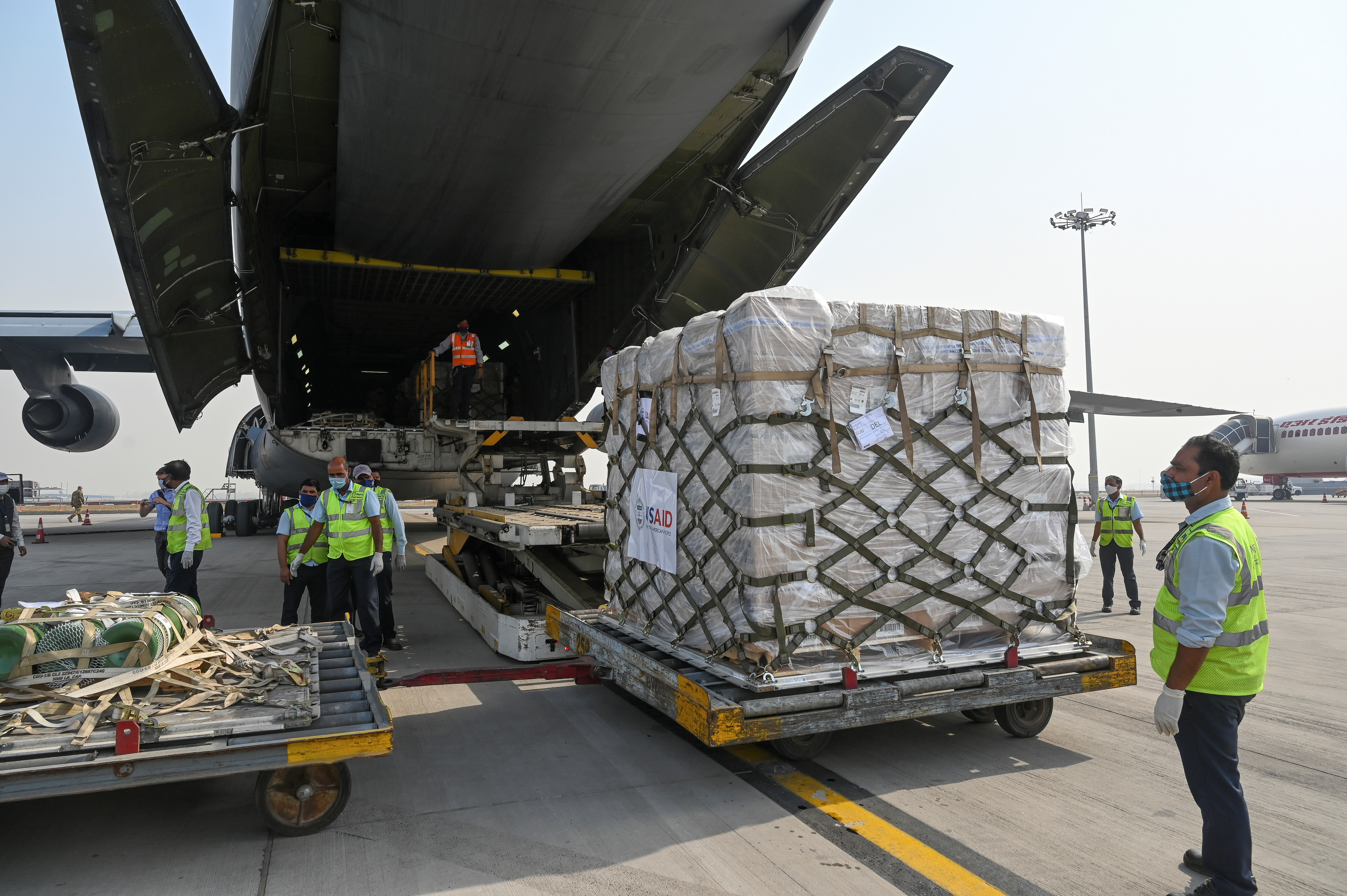 Ground staff unloading COVID-19 relief supplies from the United States at the Indira Gandhi International Airport cargo terminal in New Delhi, India on April 30, 2021