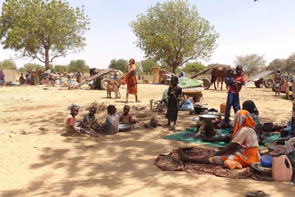 Refugees fleeing recent violence in Sudan’s Darfur region sit in shade near the town of Adre, Chad