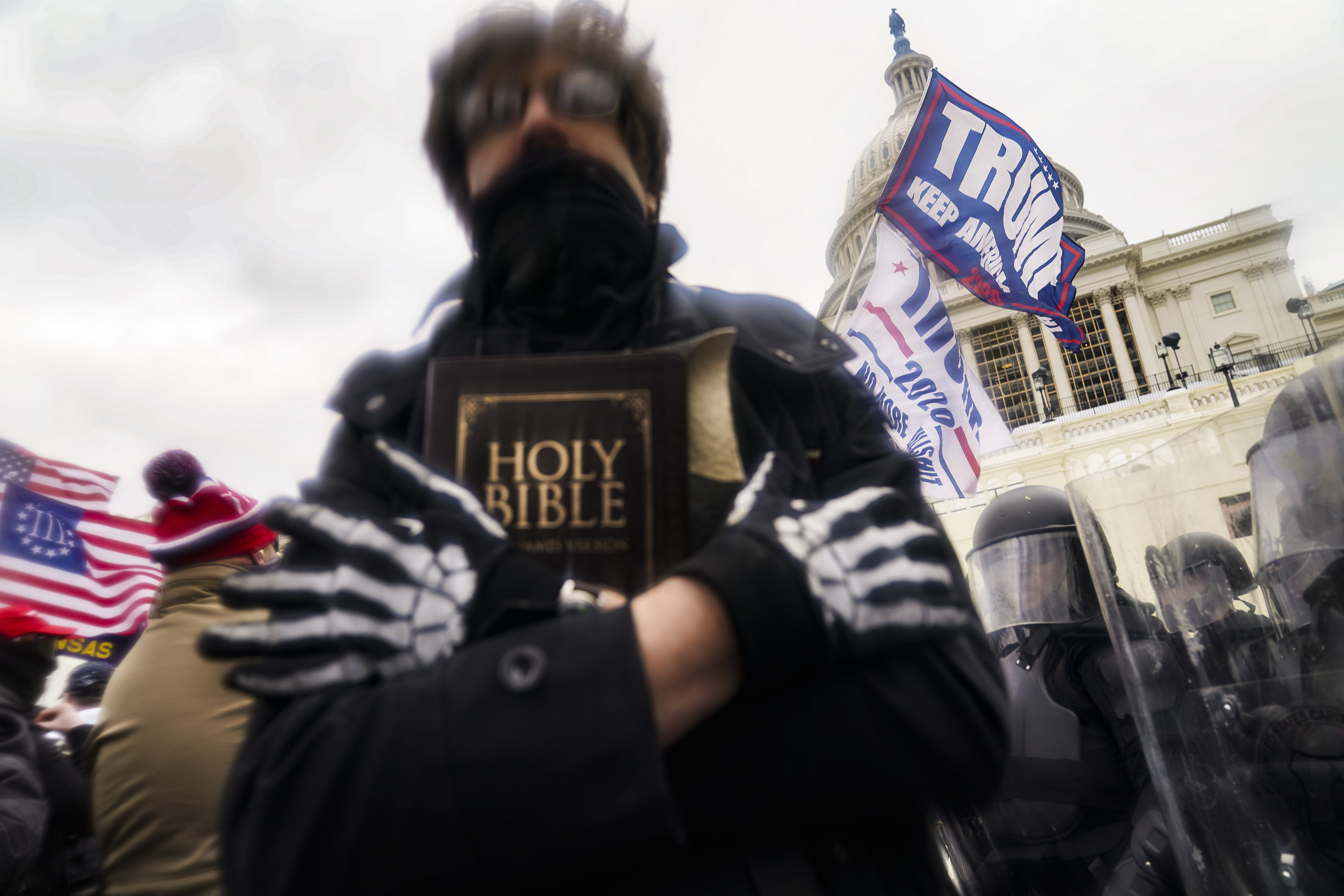 A man holds a Bible as Trump supporters gather outside the Capitol in Washington on January 6, 2021