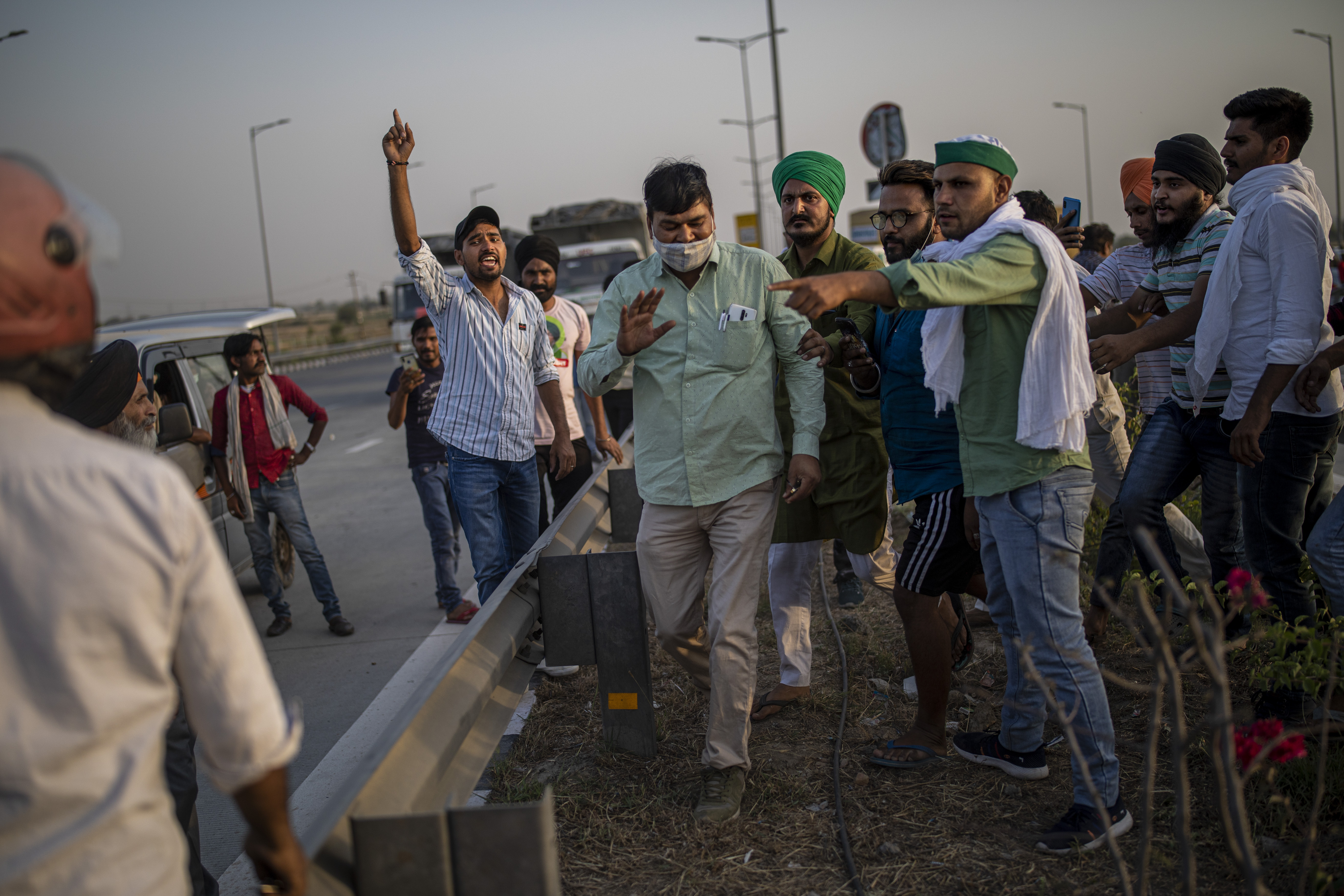 Farmers catch hold of a man, centre in light green shirt, they accuse of misbehaving with protesting farmers during their protest against new farm laws in Dasna, India