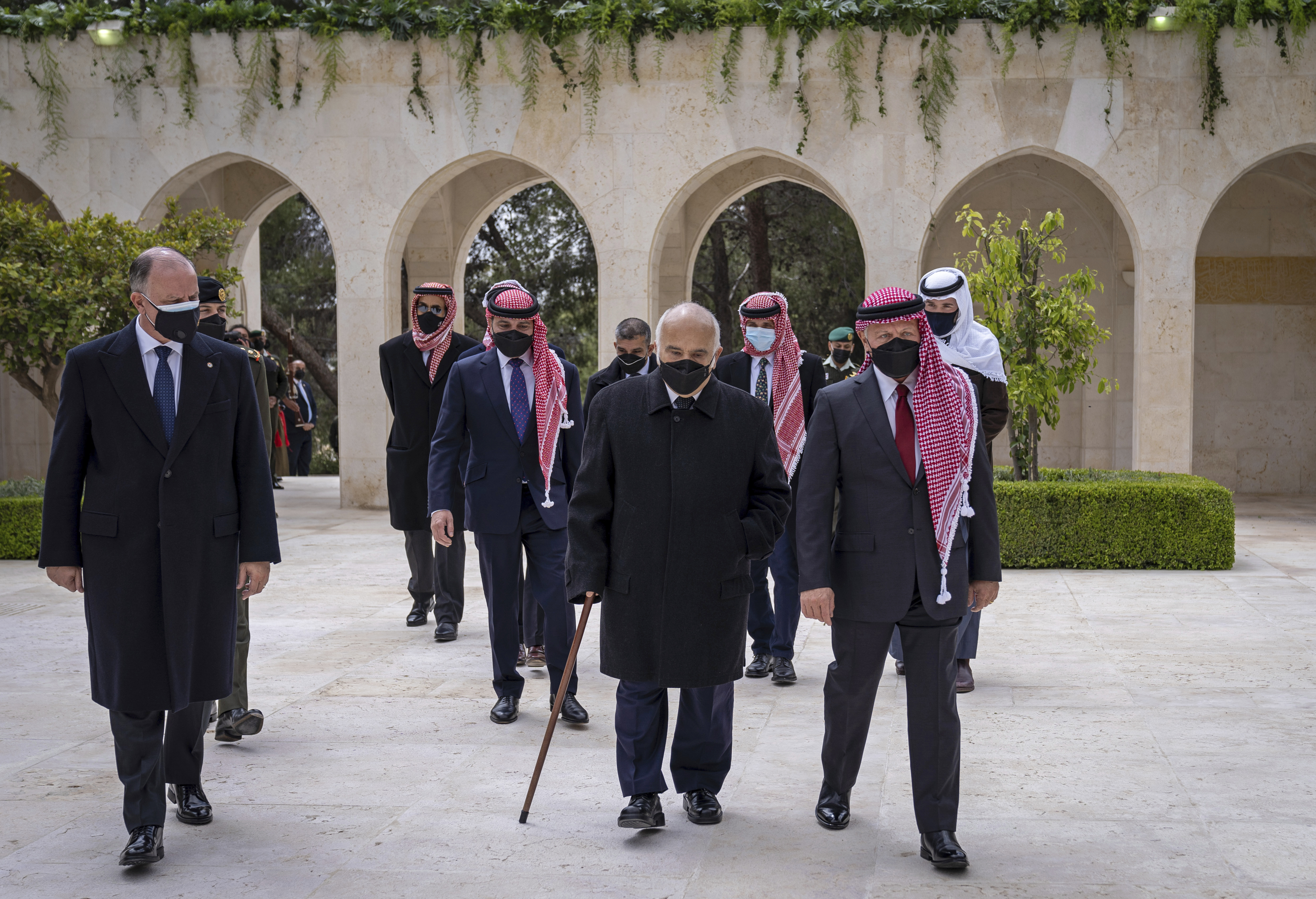 Jordan’s King Abdullah II, second right, Prince Hamzah bin Al Hussein, fourth right in blue mask, Prince Hassan bin Talal, fifth right, in their first joint public appearance since a palace feud in April, 2021