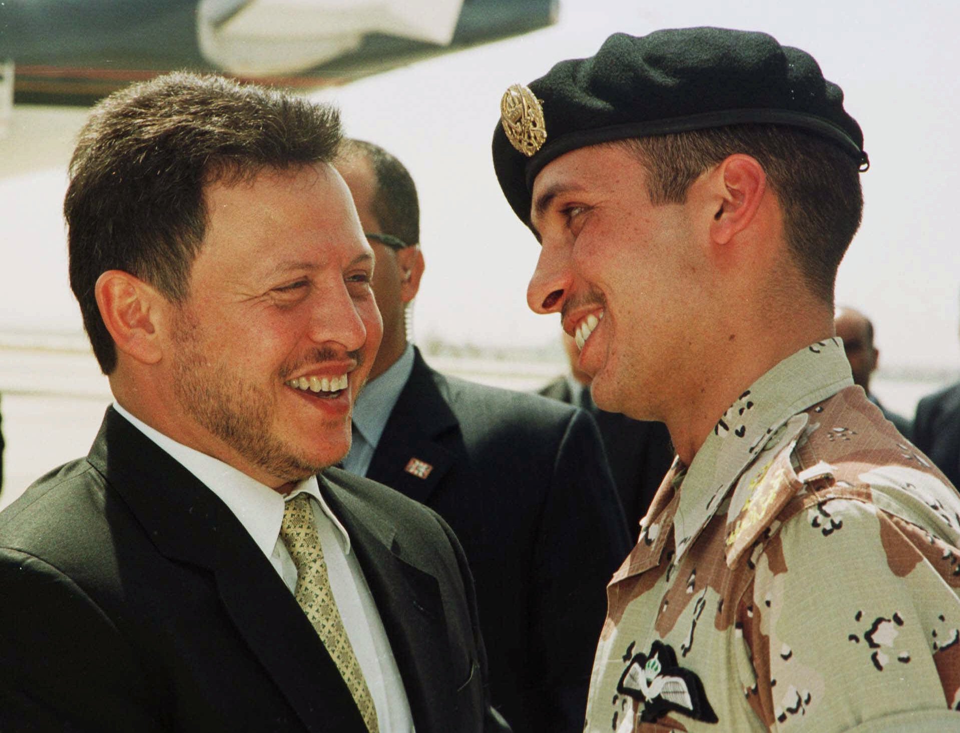 Jordan’s King Abdullah II laughs with his brother Crown Prince Hamzah, right, in 2001